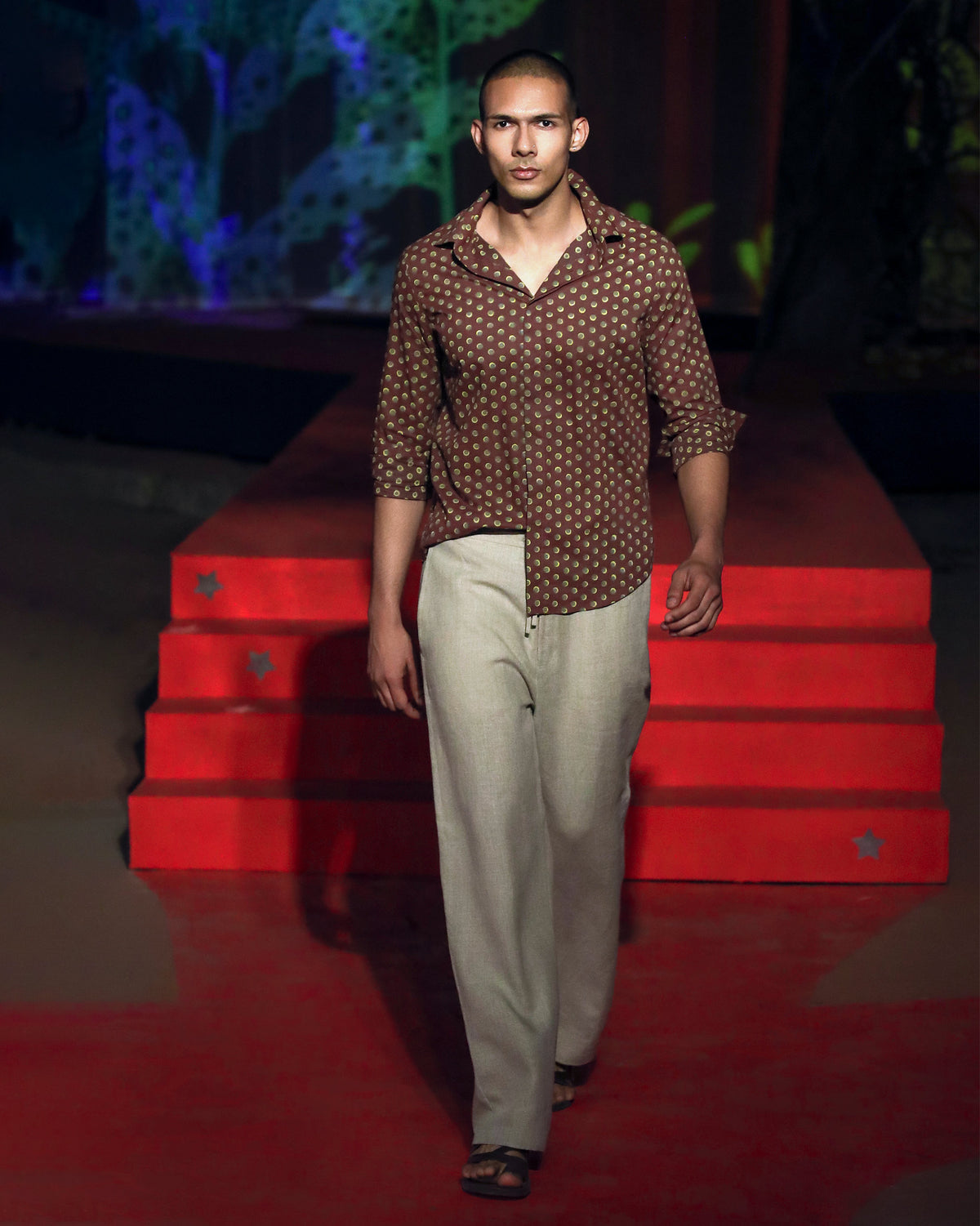 Person wearing a brown Pipit Shirt with a lime circular print at full length.