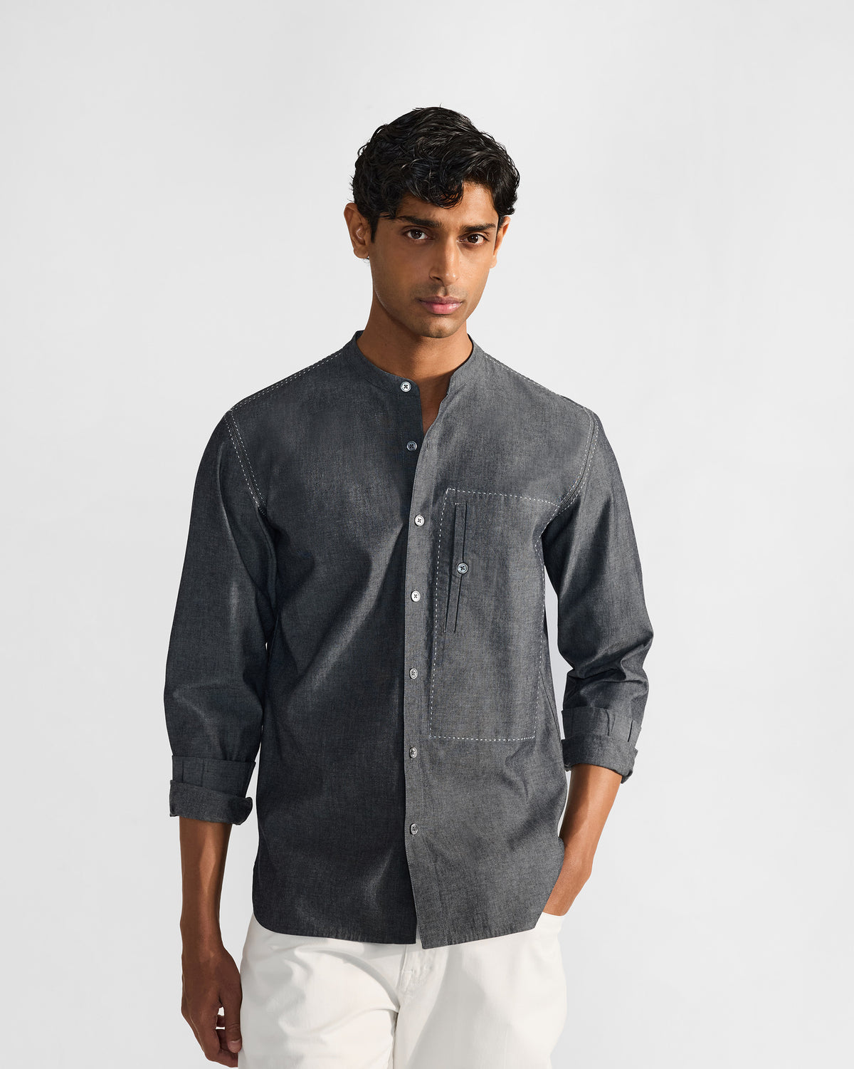 Person wearing a charcoal Marten shirt with a white-stitched chest pocket.