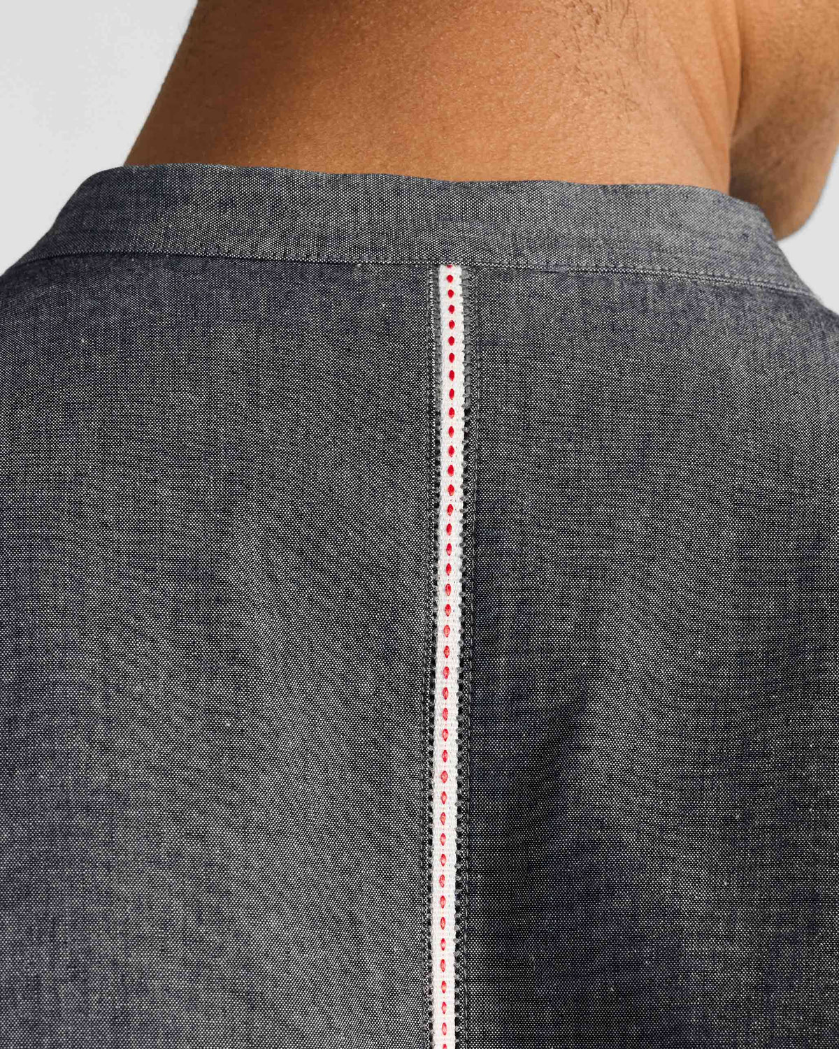 Close-up of the white back stripe with red stitch on a charcoal Marten shirt.