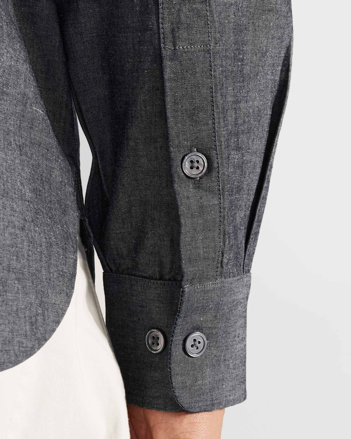 Close-up of the buttoned cuff on a charcoal Marten shirt.