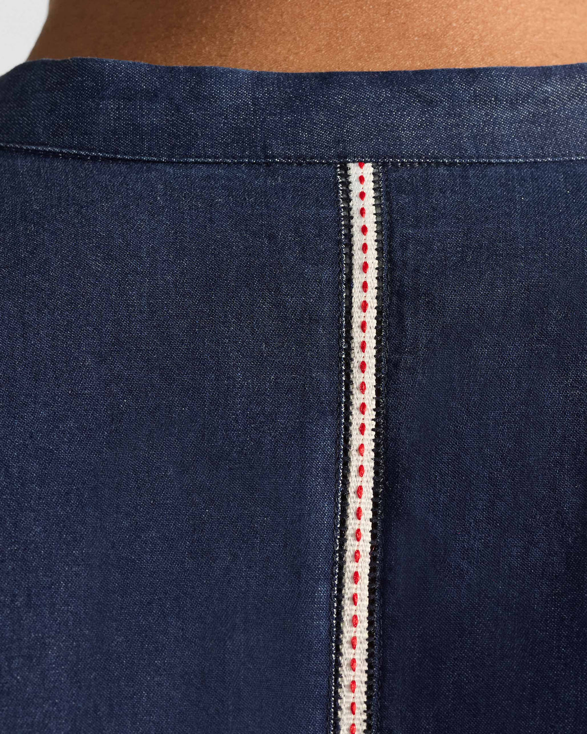 Close-up of white trim at the neckline of an indigo Loris shirt.