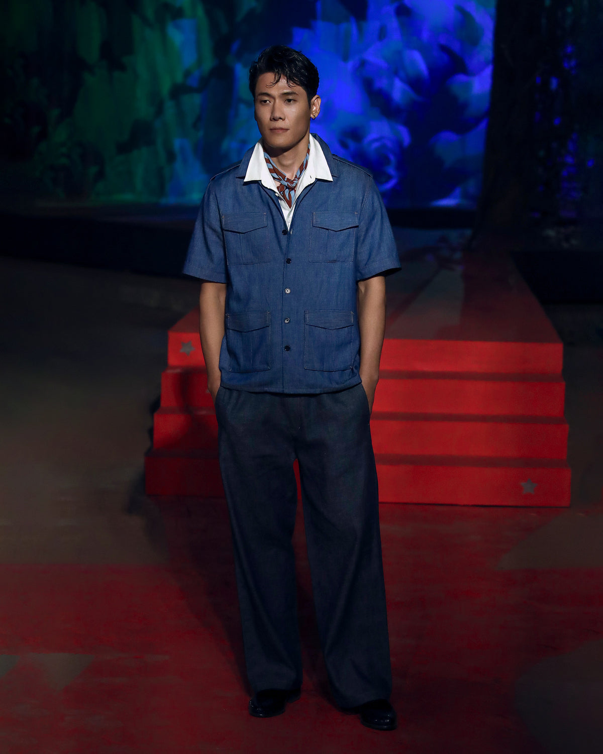 Person wearing a blue denim Sambar shacket with four flapped pockets.