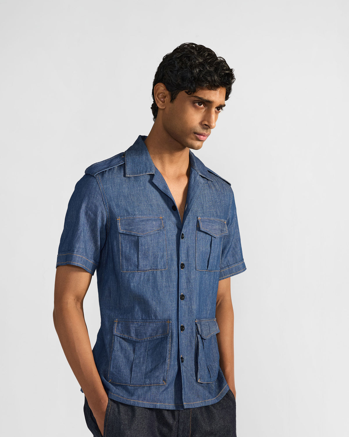 Person wearing a short-sleeve blue denim Sambar shacket with utility pockets.