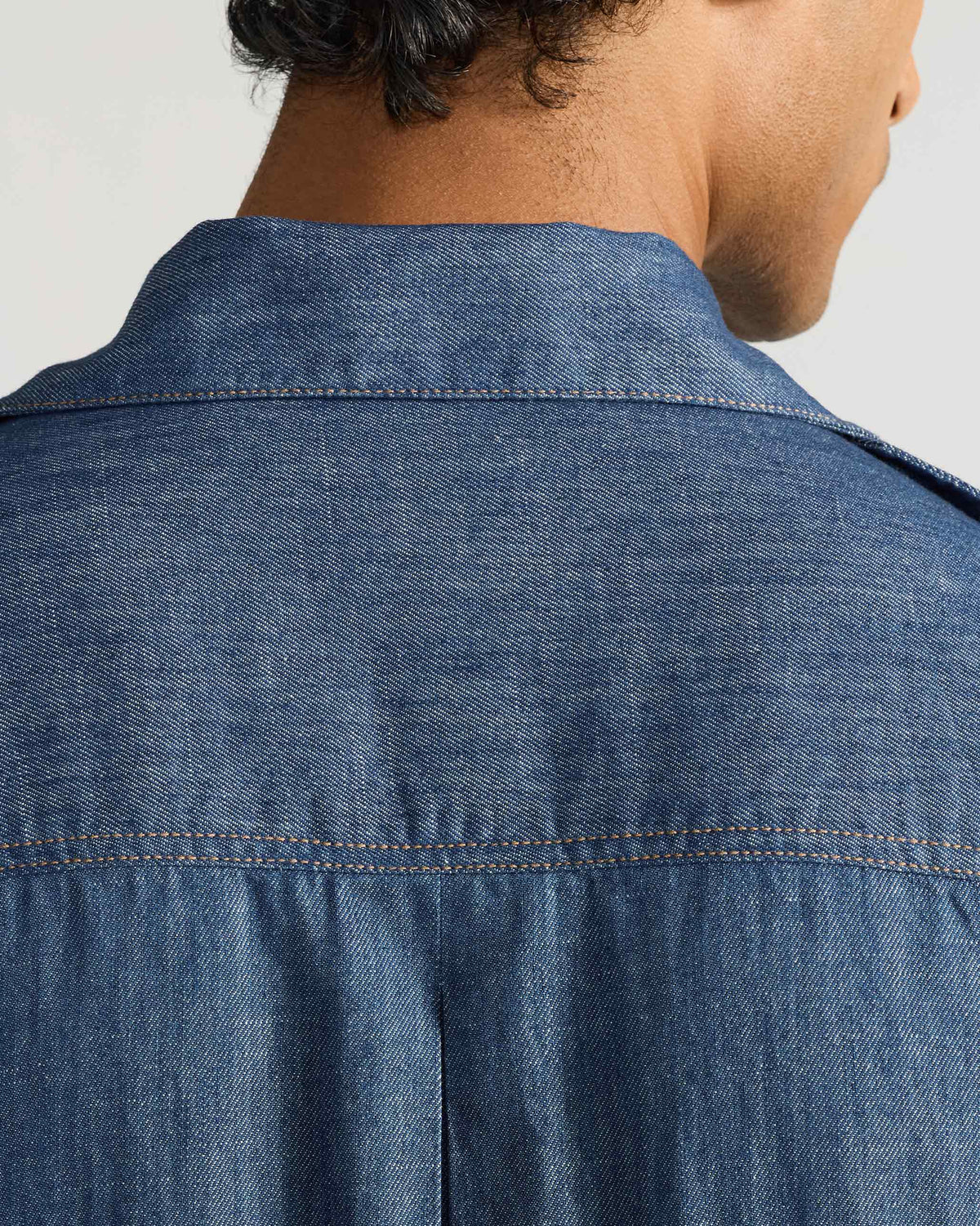 Close-up of the back yoke and collar on a blue denim Sambar shacket.