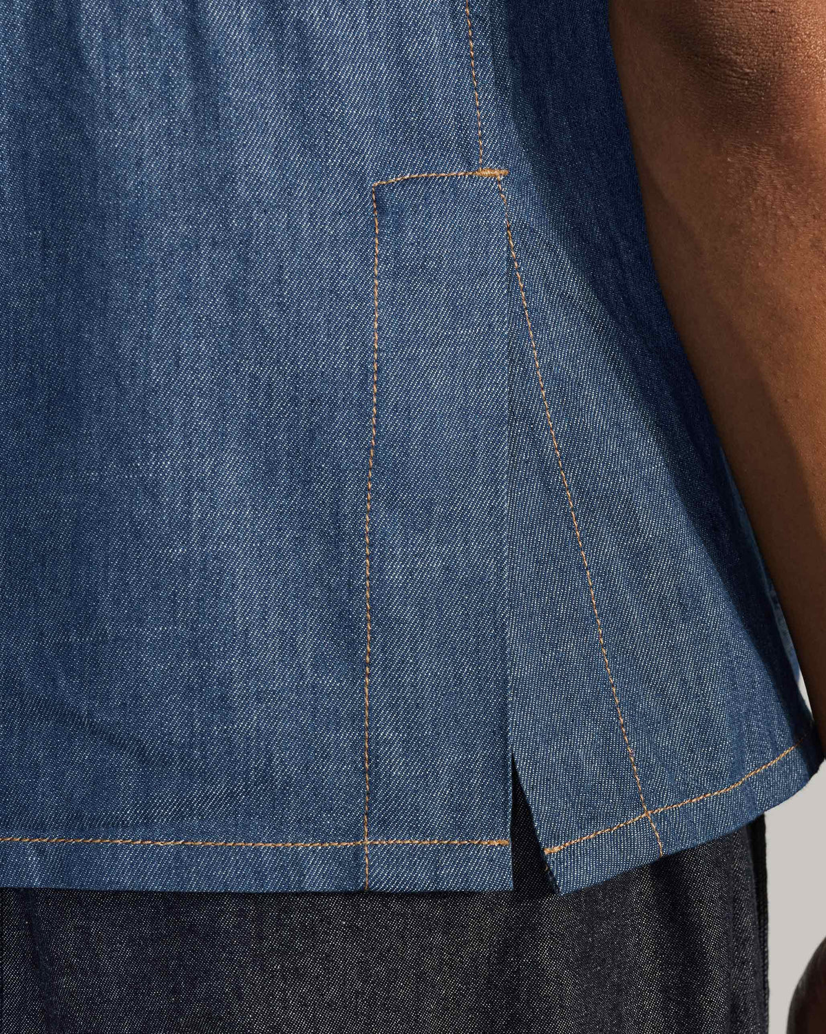 Close-up of the side vent on a blue denim Sambar shacket.