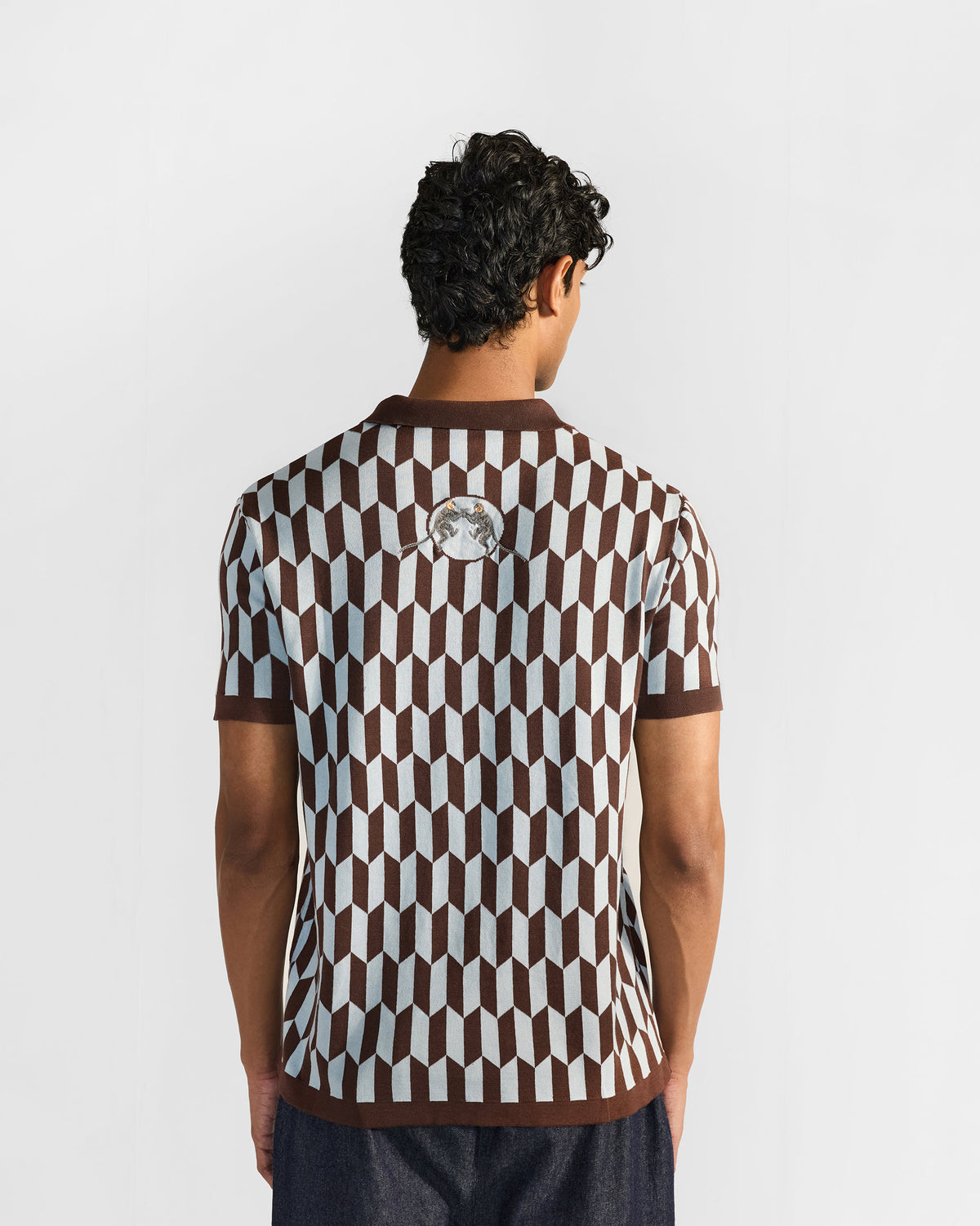 Back of a brown and light grey Langur polo with facing monkeys below the collar.