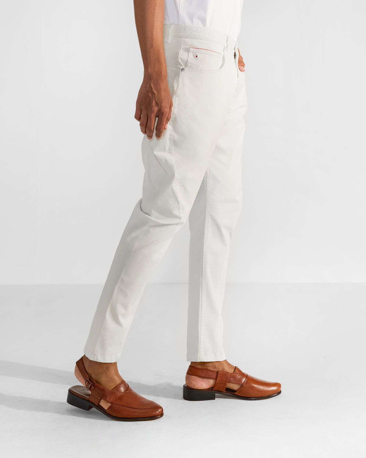Side view of off-white Serow jodhpur pants tapering at the ankle.