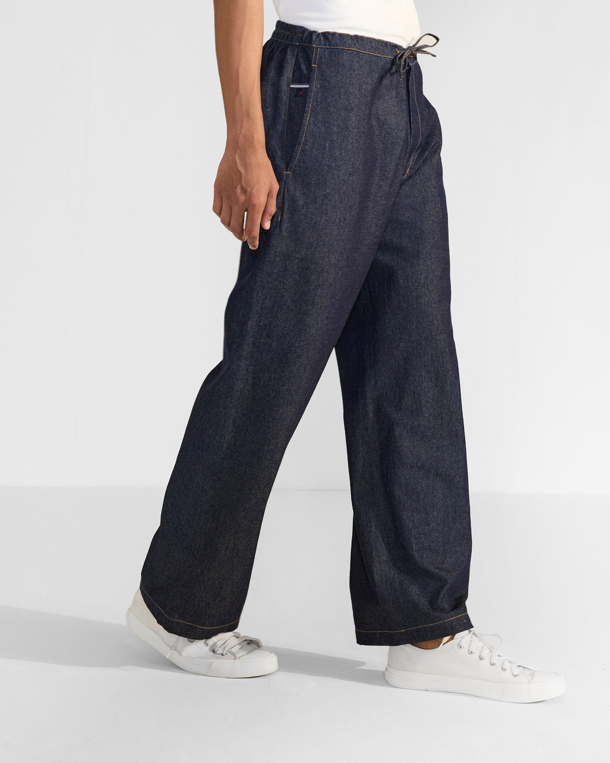 Side view of denim Thrush Trousers showing the wide-leg drape.