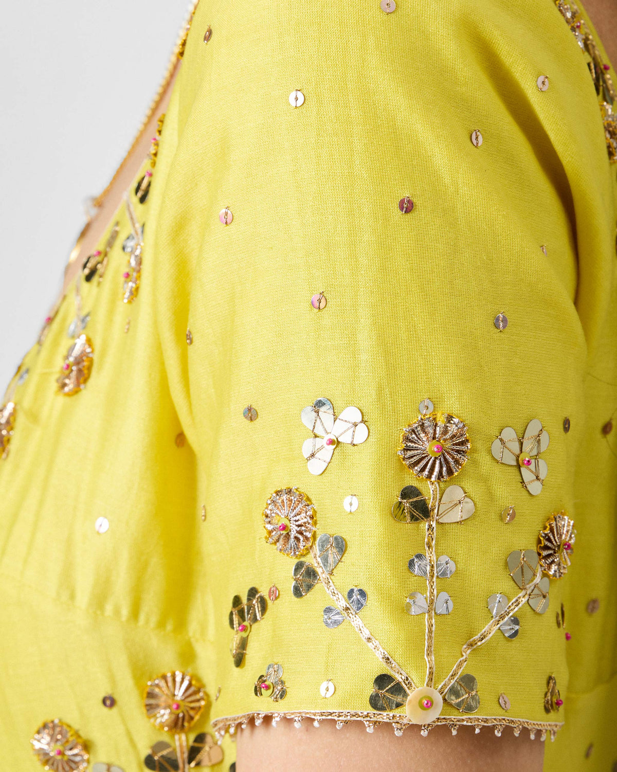 Close-up of gold gota and sequin embroidery on a yellow Cherai kurta sleeve.