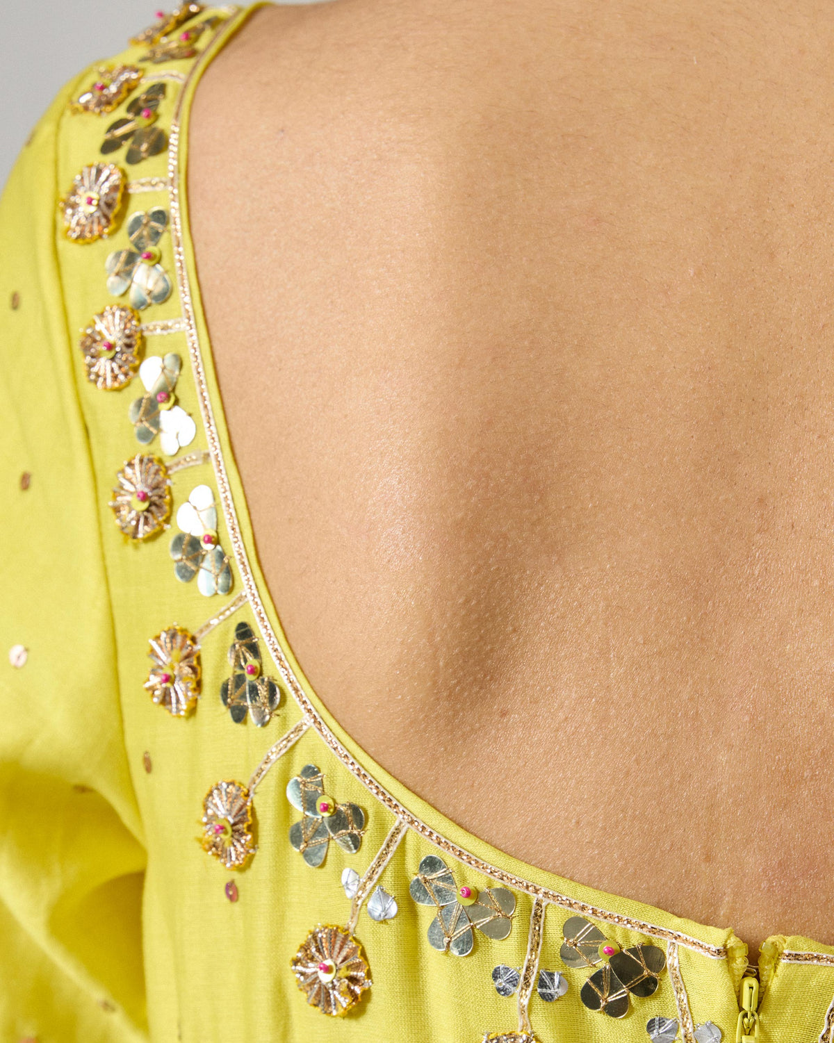 Close-up of the deep U back neckline on a yellow Cherai kurta with gota trim.