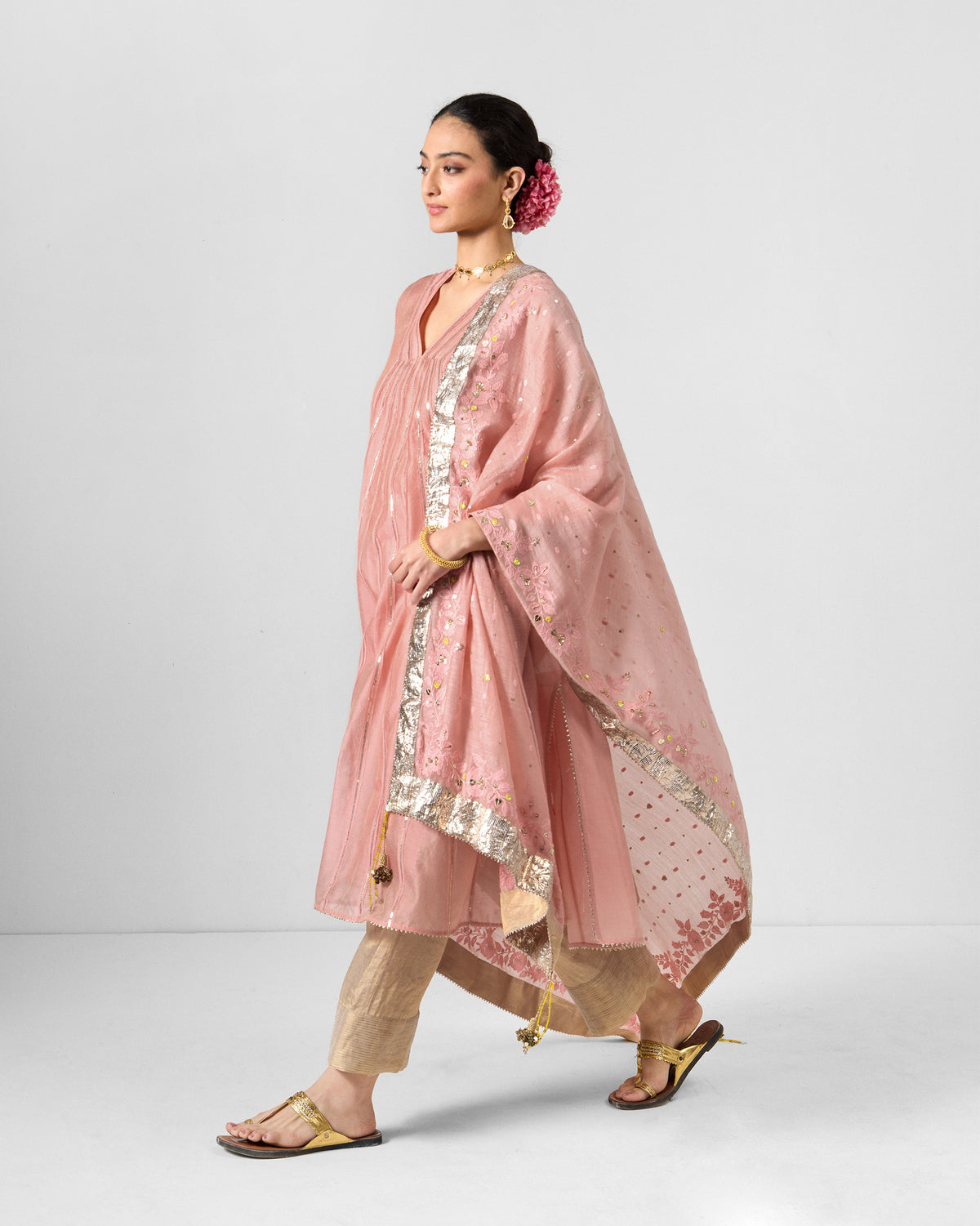 Person wearing a pink embroidered Sukhna kurta with slip and a sheer bordered dupatta.