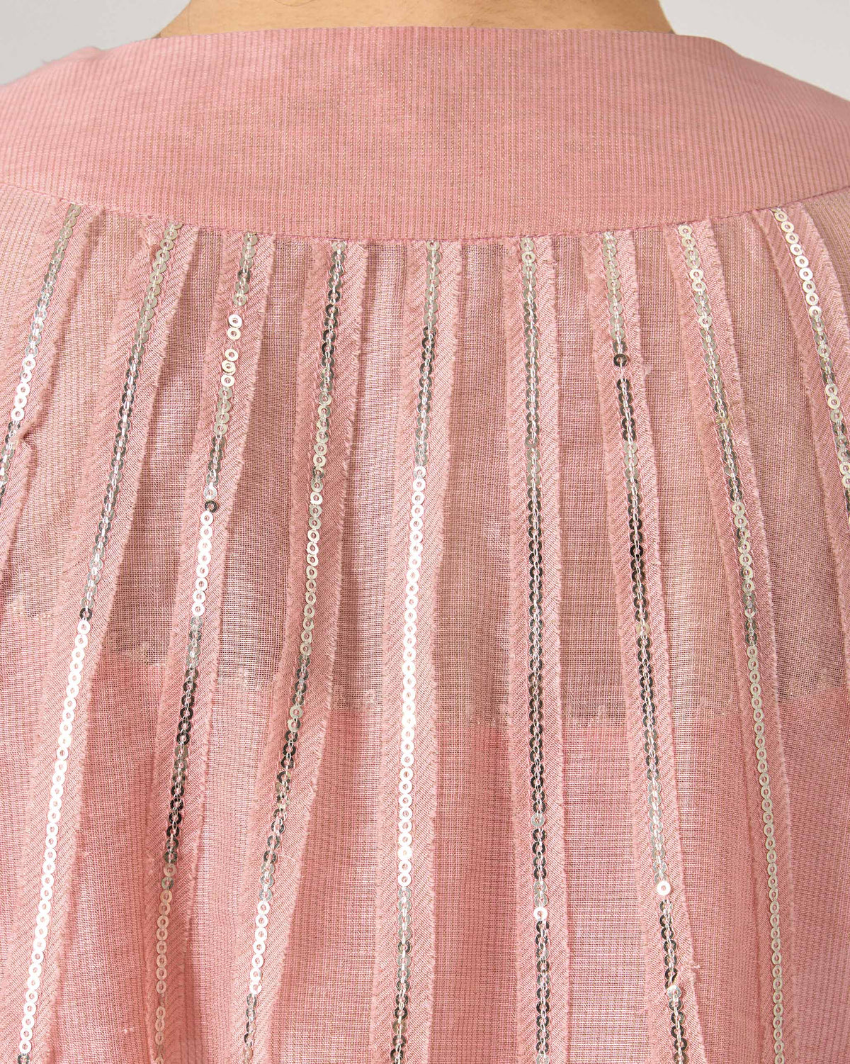 Close-up of silver sequin stripes on the back of a pink embroidered Sukhna kurta.