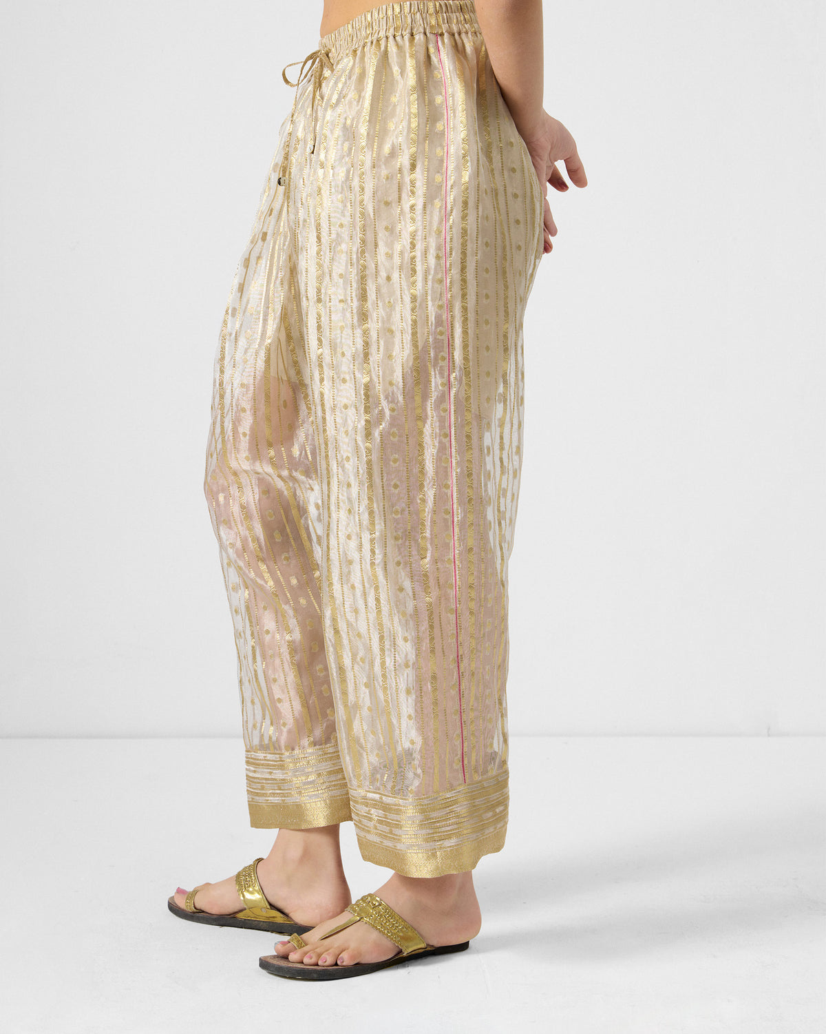 Side view of a Ghoom Salwar in sheer gold-toned stripes with a drawstring waist.