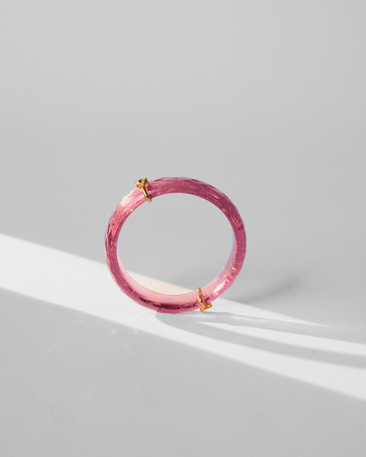 Side view of a Shaan Bangle standing upright, with gold accents.