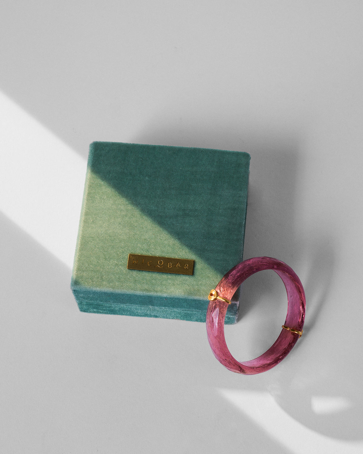 Shaan Bangle laid beside a green velvet Nicobar box.