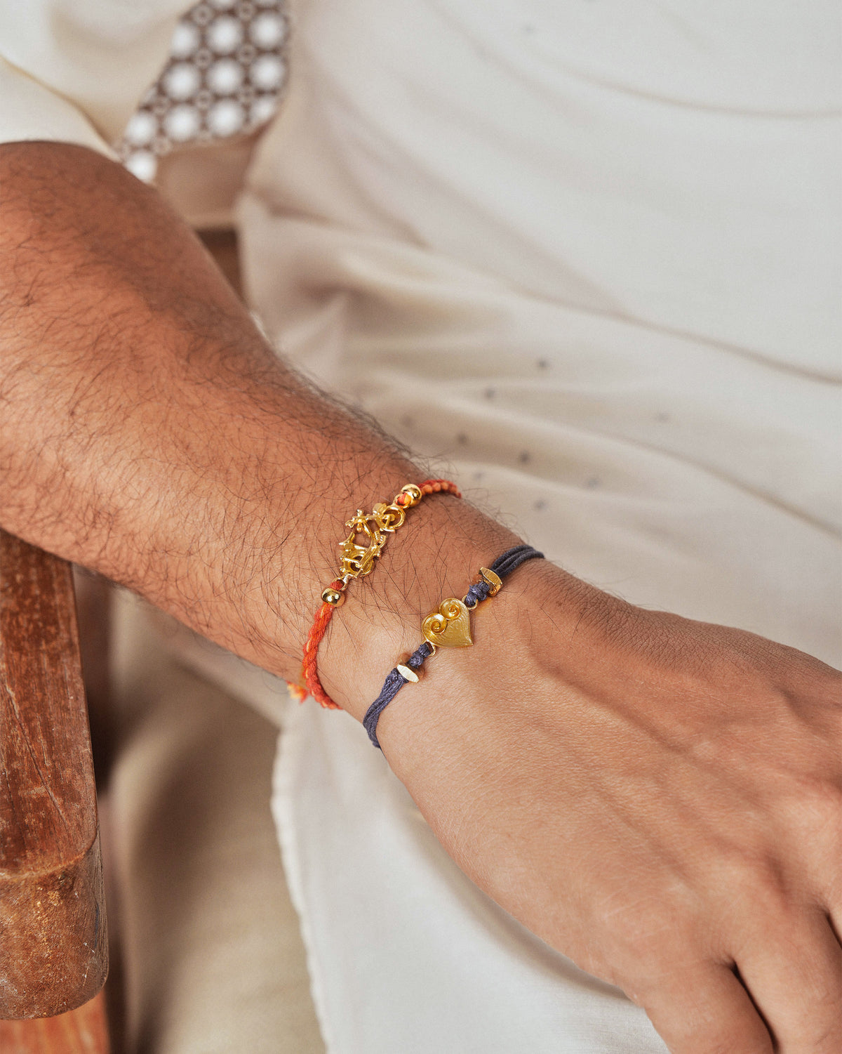 Person wearing a blue Dil Rakhi with a gold heart charm.