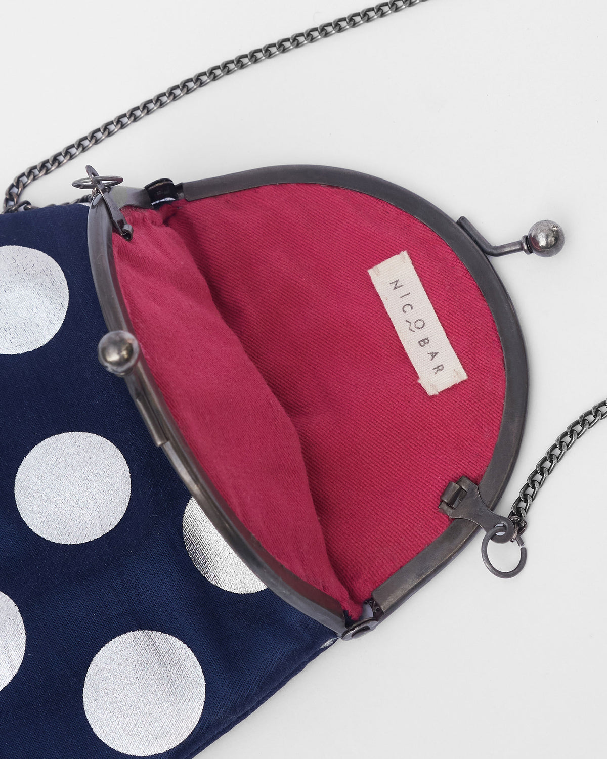 Close-up of the Dottie Clutch open to show the pink lining and Nicobar label.