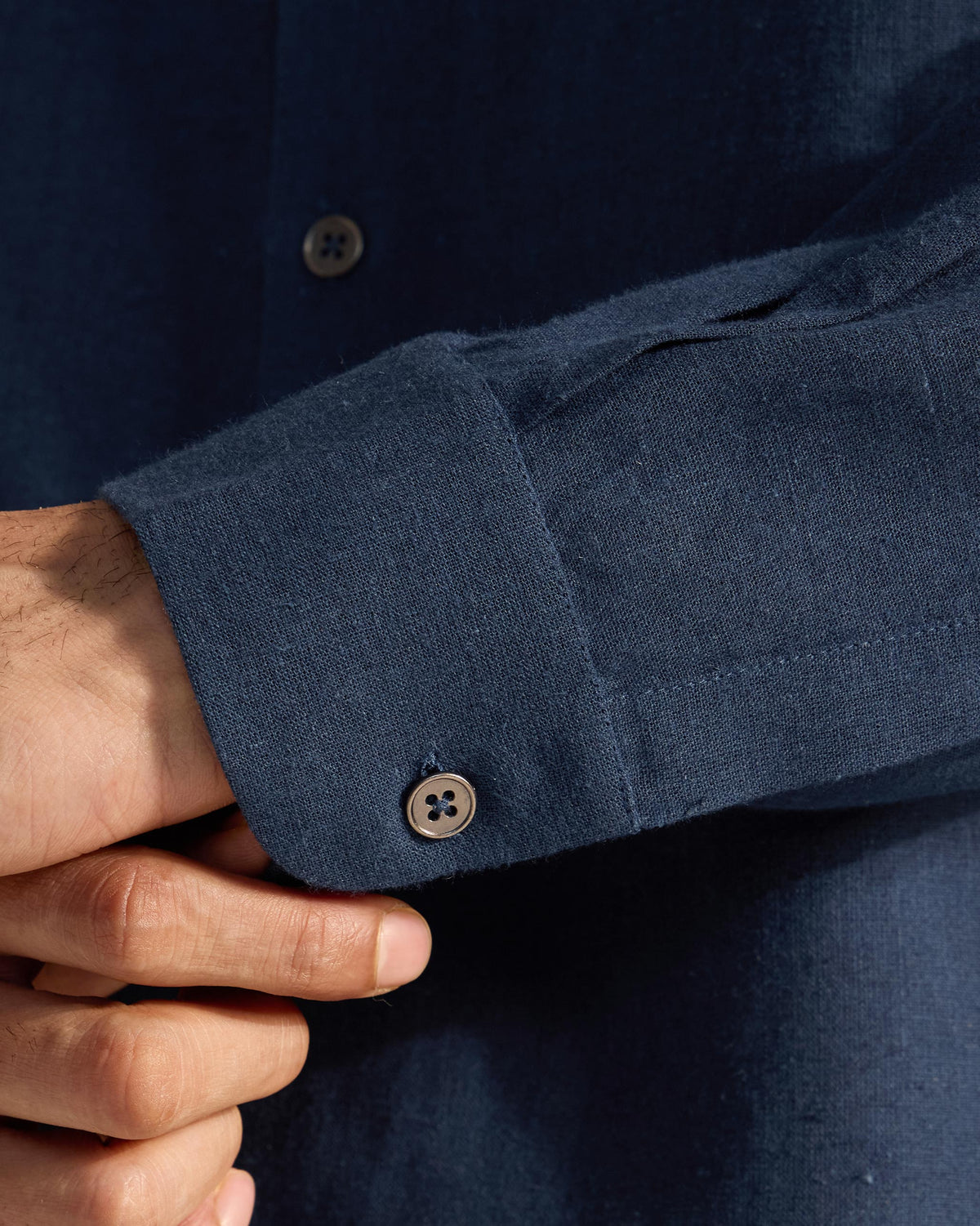 Close-up of the linen cuff on a navy Rewa shirt.