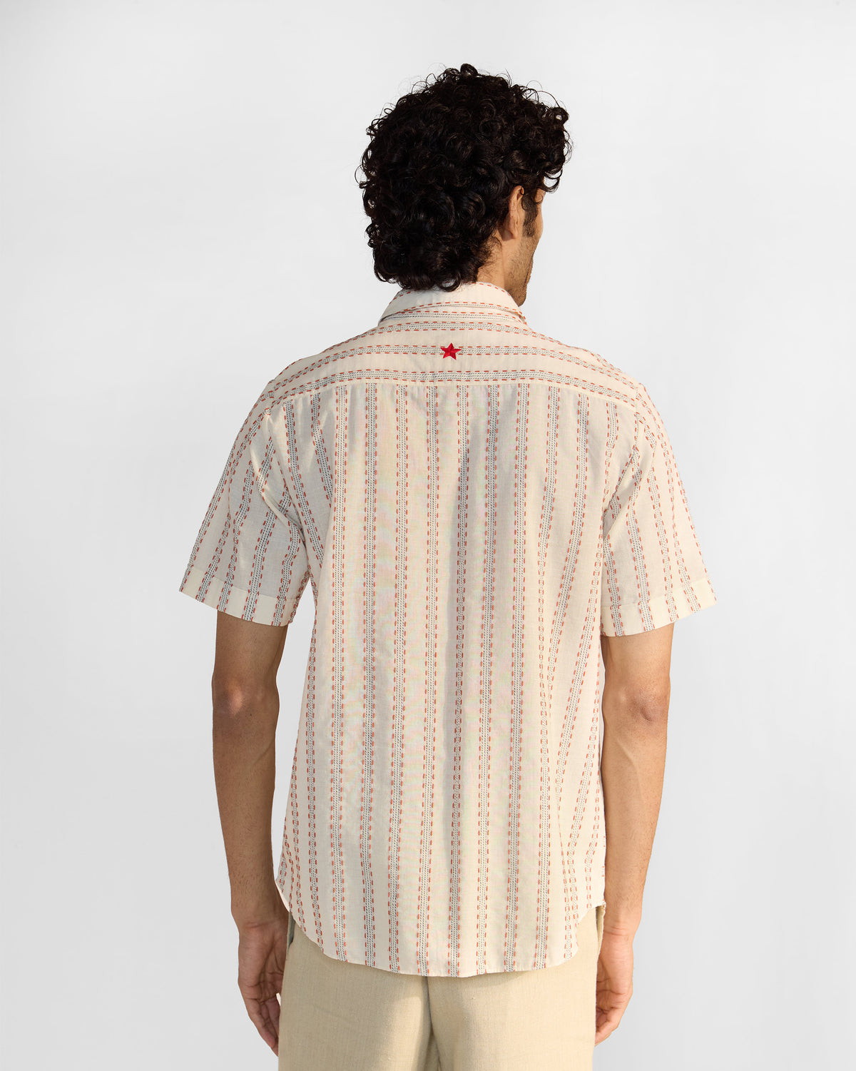 Back of an ivory Half Sleeves Shirt with a red embroidered star on the yoke.