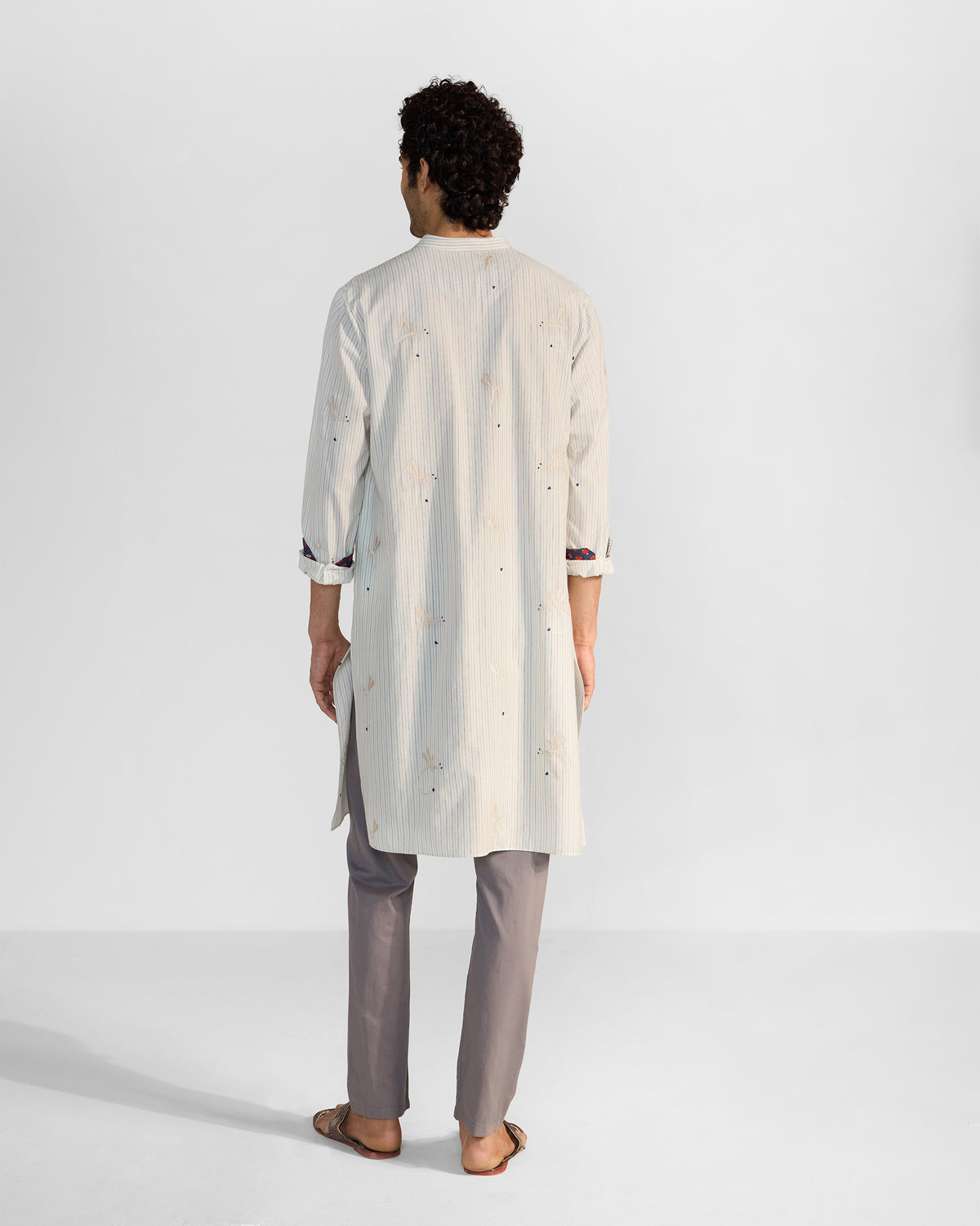 Back of an ivory Astral kurta with dragonfly embroidery and navy cuff lining.