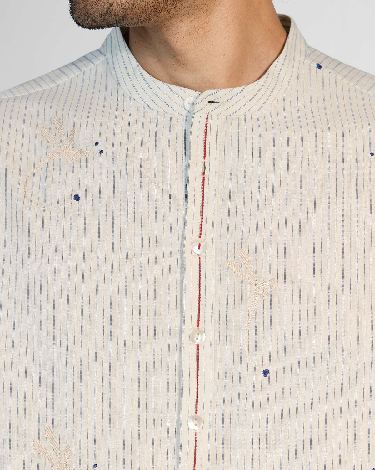 Close-up of Astral kurta collar with dragonfly embroidery and red faggoting.