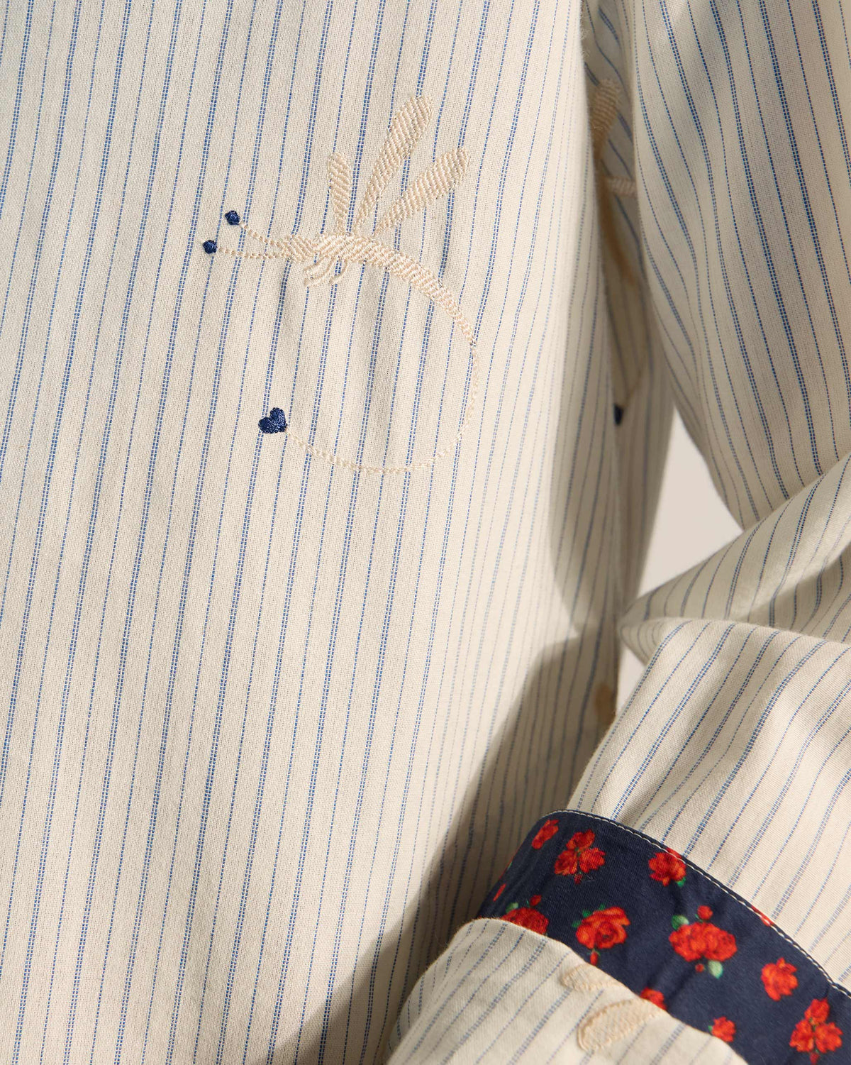 Close-up of Astral kurta dragonfly embroidery and navy rose-print cuff.