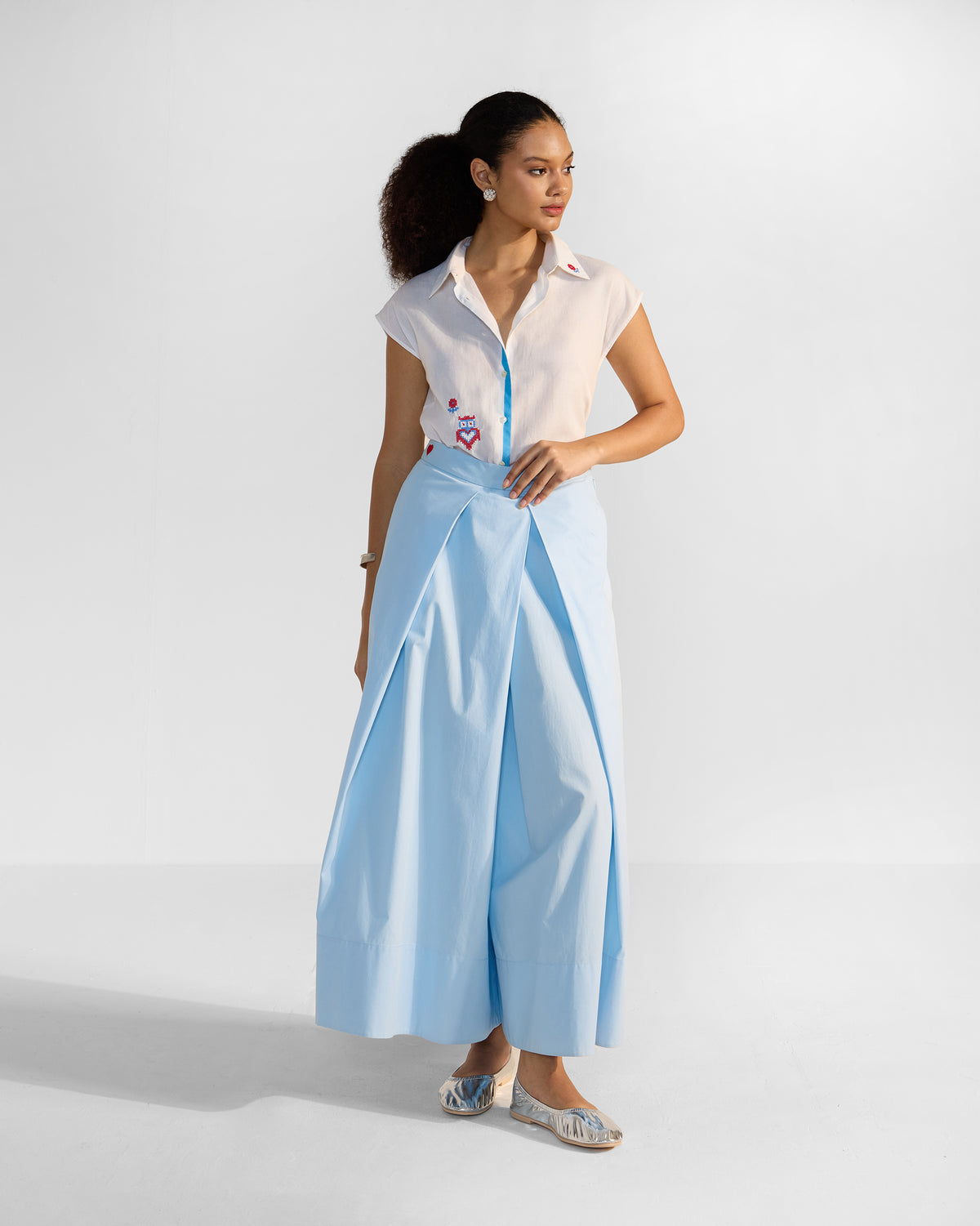 Person wearing a white Eira top tucked to show the blue placket.