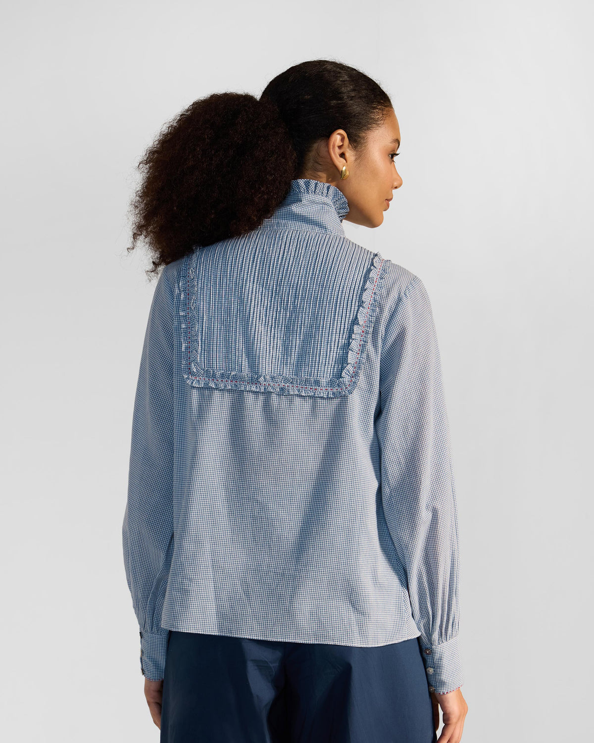 Back of a blue check Lona top with a pleated yoke.