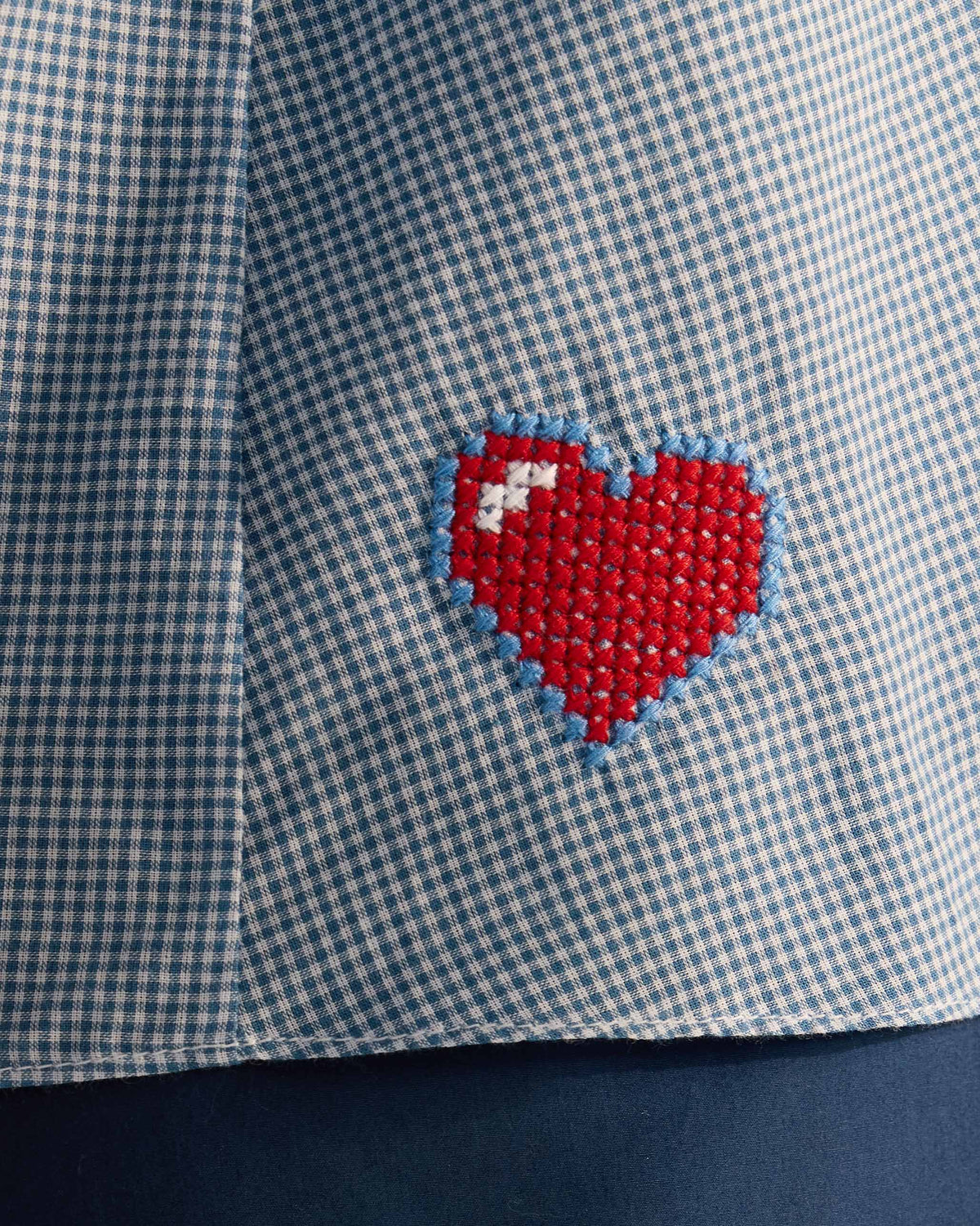 Close-up of a red heart on a blue check Lona top.