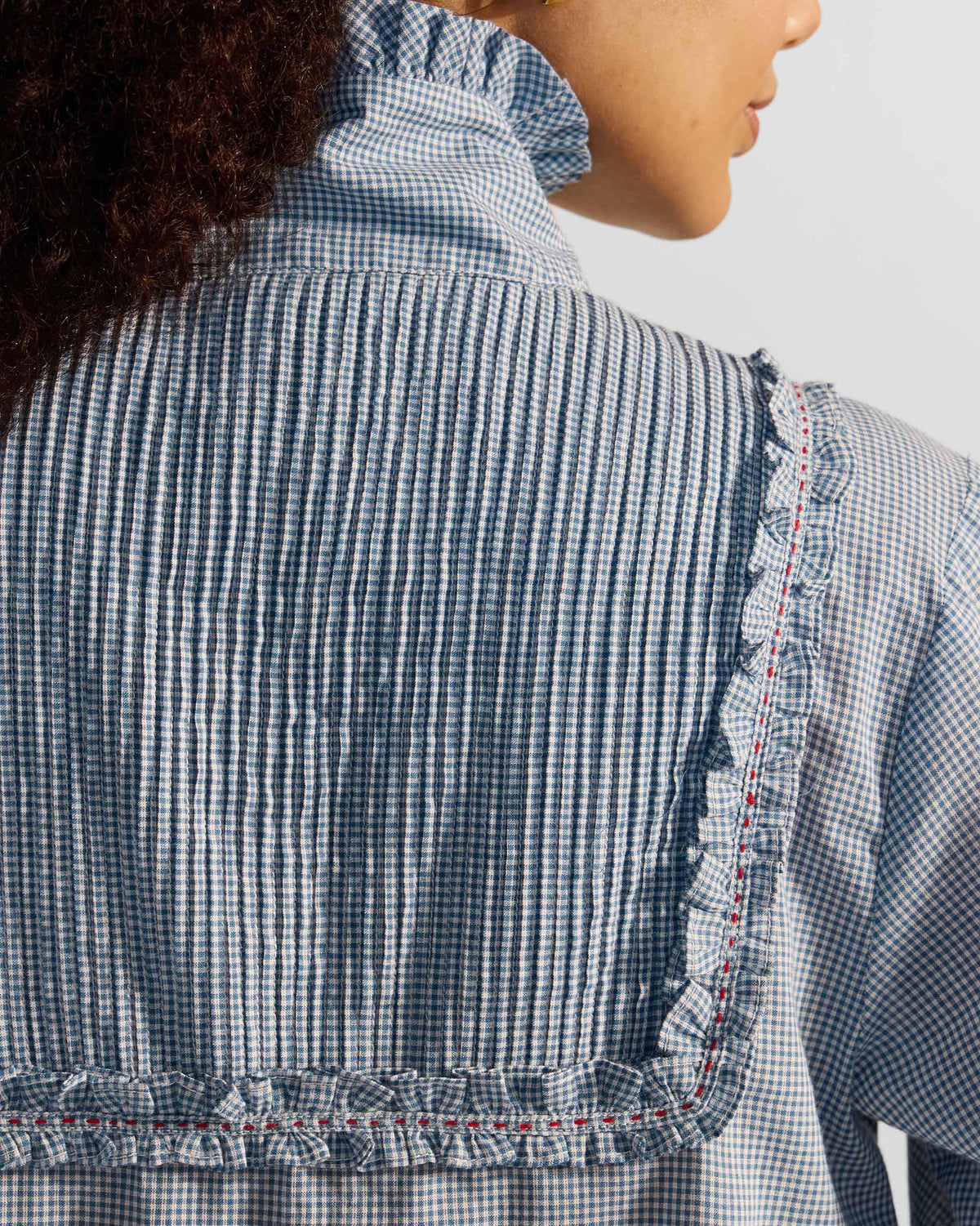 Close-up of the pleated back yoke on a blue check Lona top.