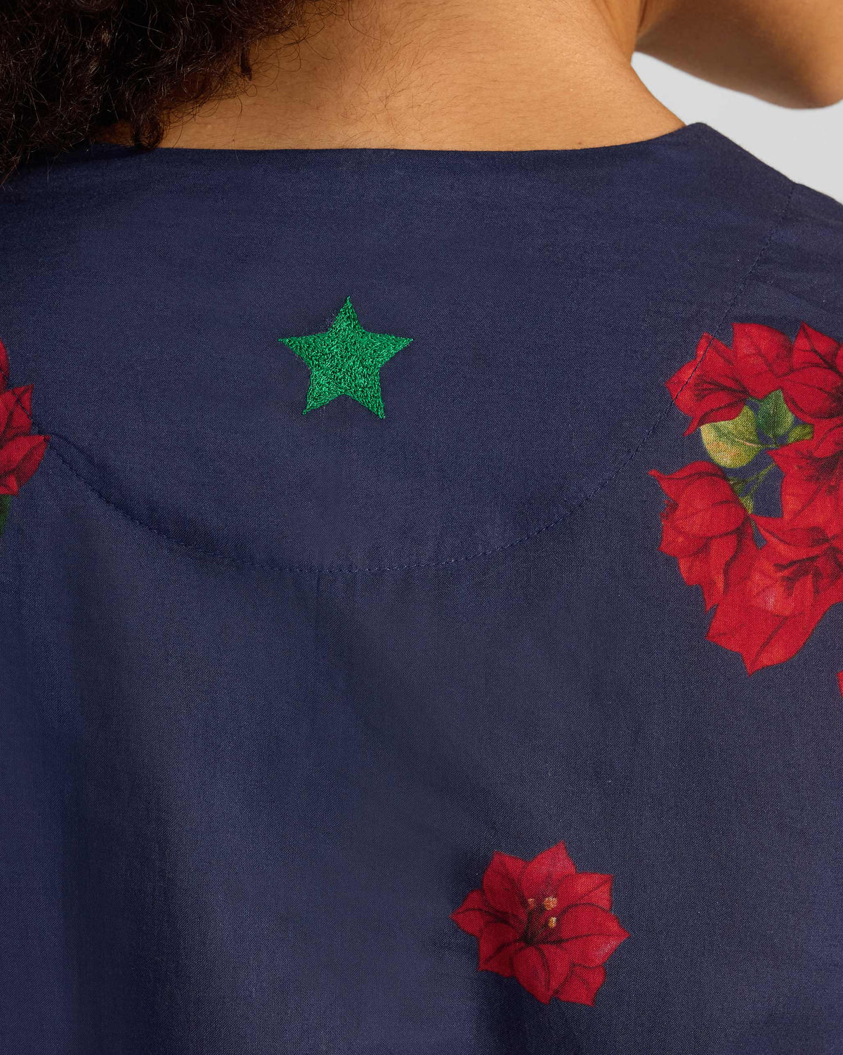 Close-up of a Kaari Kurta showing red floral print and a green star at the neck.