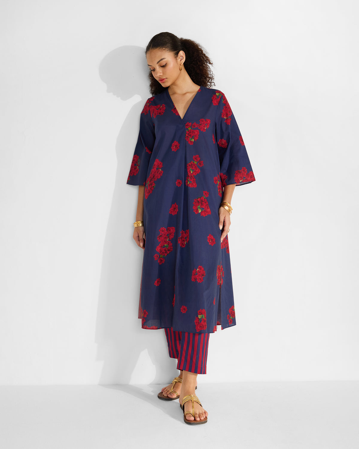 Person wearing a blue Kaari Kurta with a red botanical print.