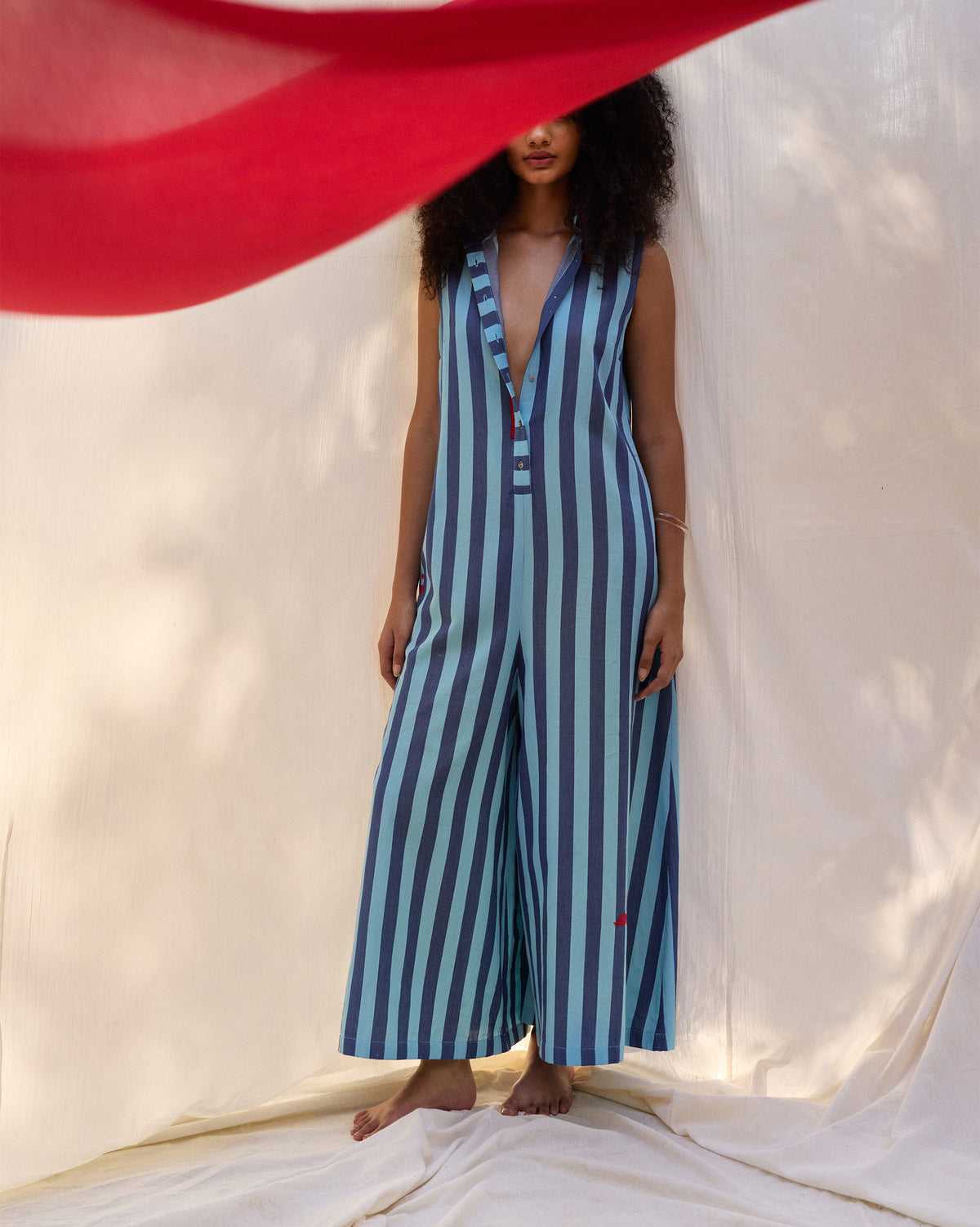 Person wearing a blue stripe Bargi jumpsuit with a deep V placket.