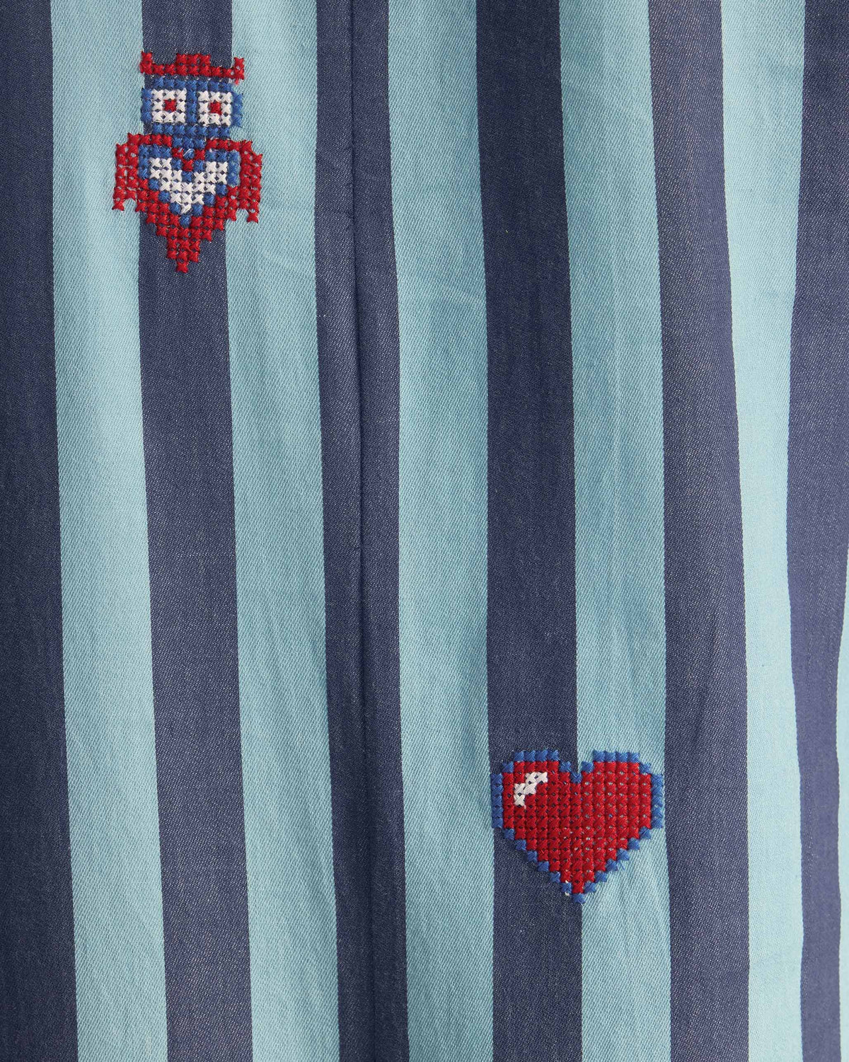 Close-up of Bargi jumpsuit stripes with owl and heart embroidery.