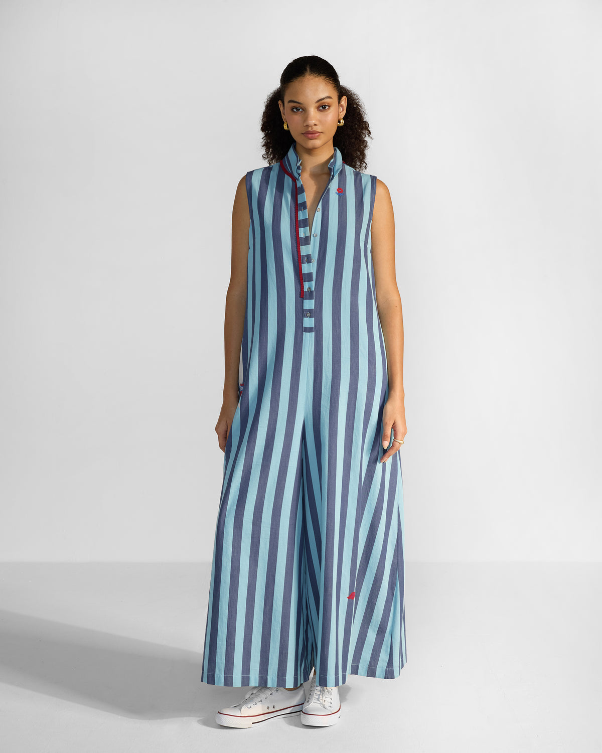 Person wearing a blue stripe Bargi jumpsuit with red collar trim.