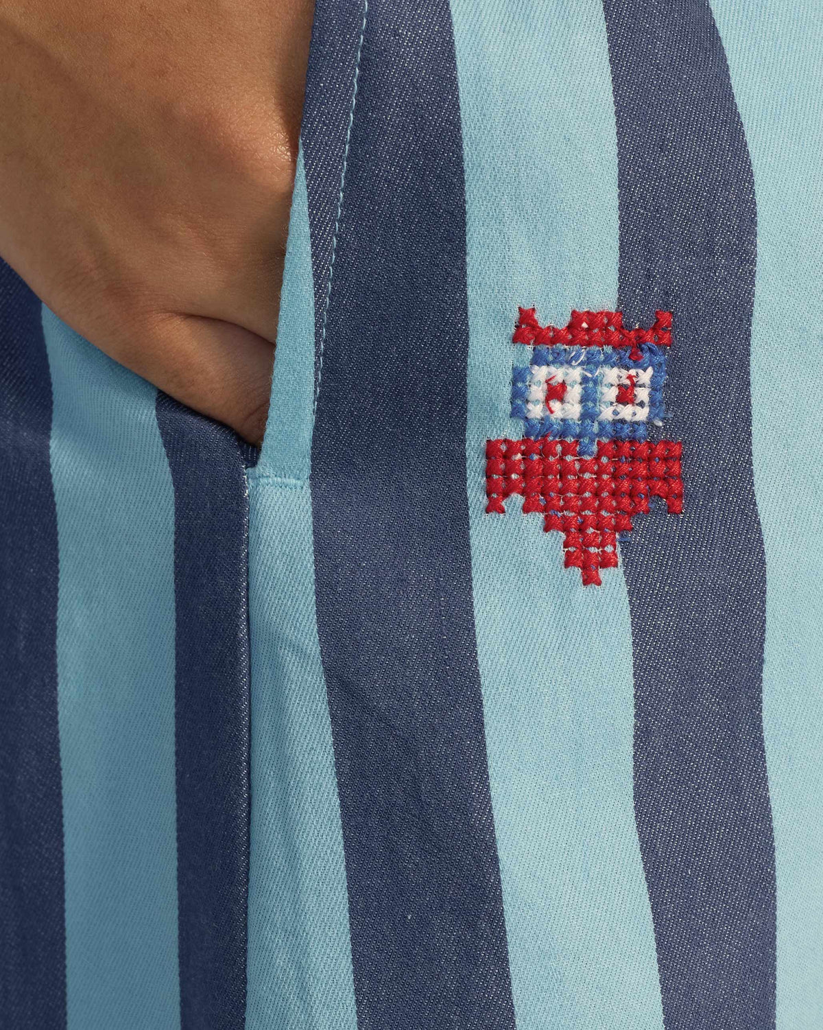 Close-up of a Bargi jumpsuit pocket with a red owl embroidery.