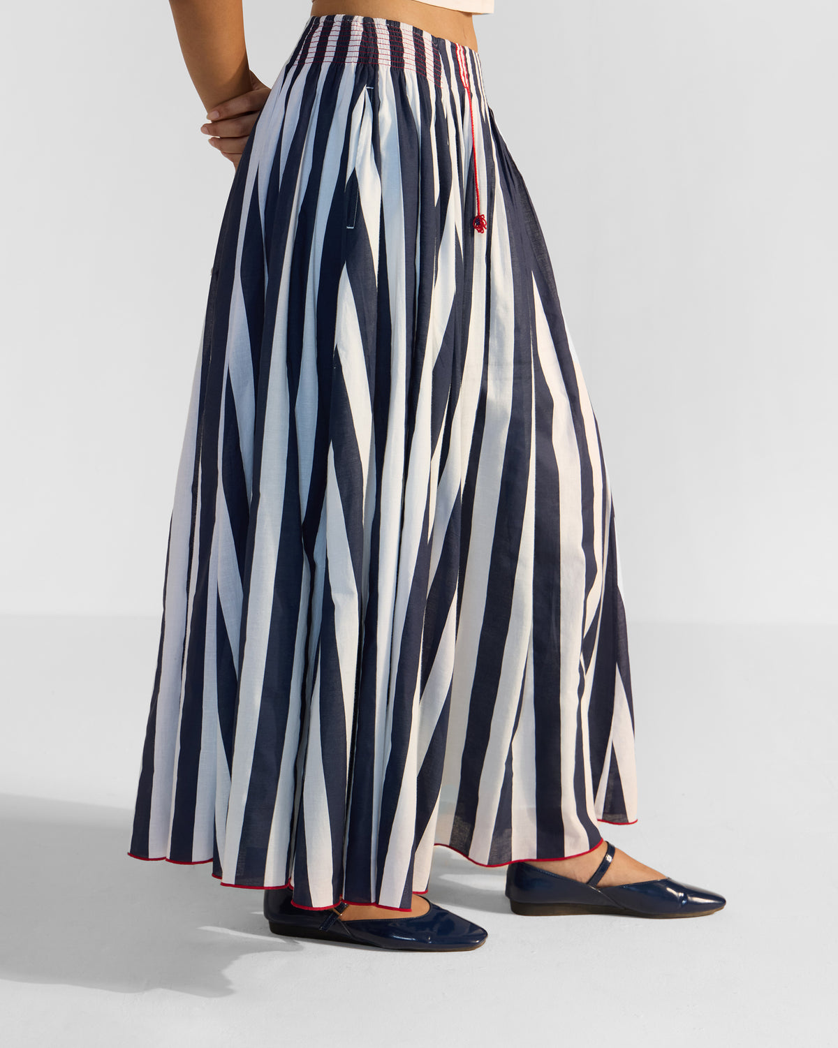 Side view of a navy and white striped Reyat maxi skirt.