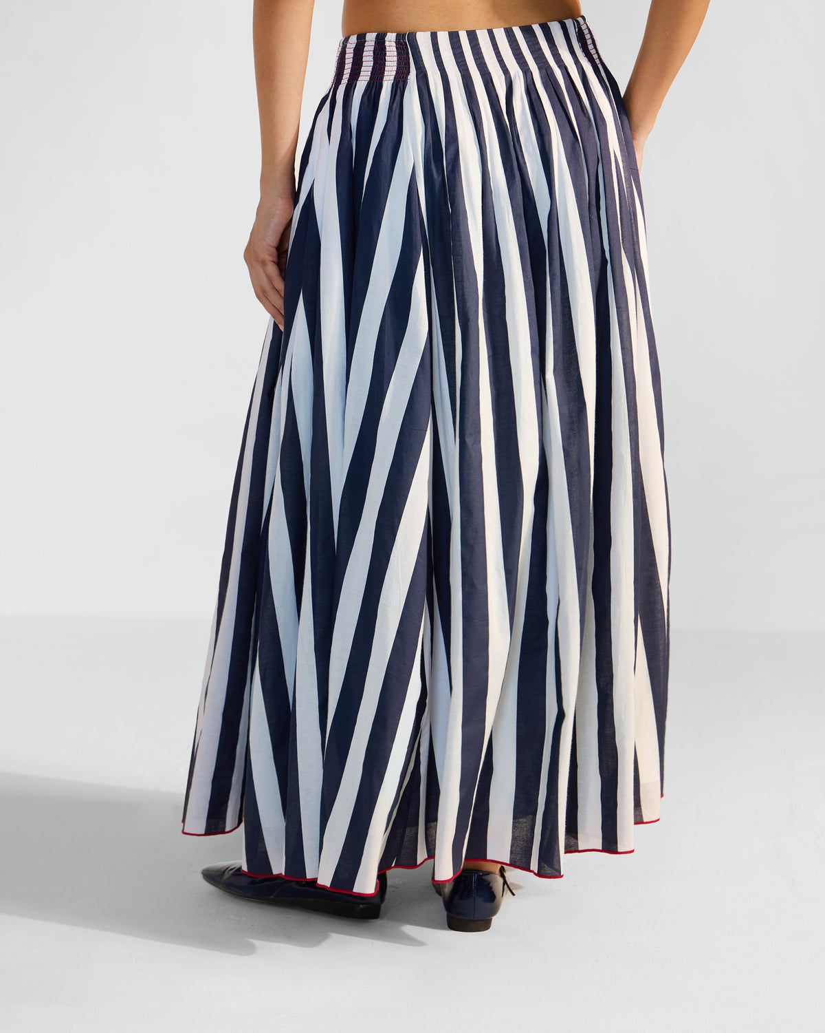 Back of a navy and white striped Reyat skirt with a smocked waist.
