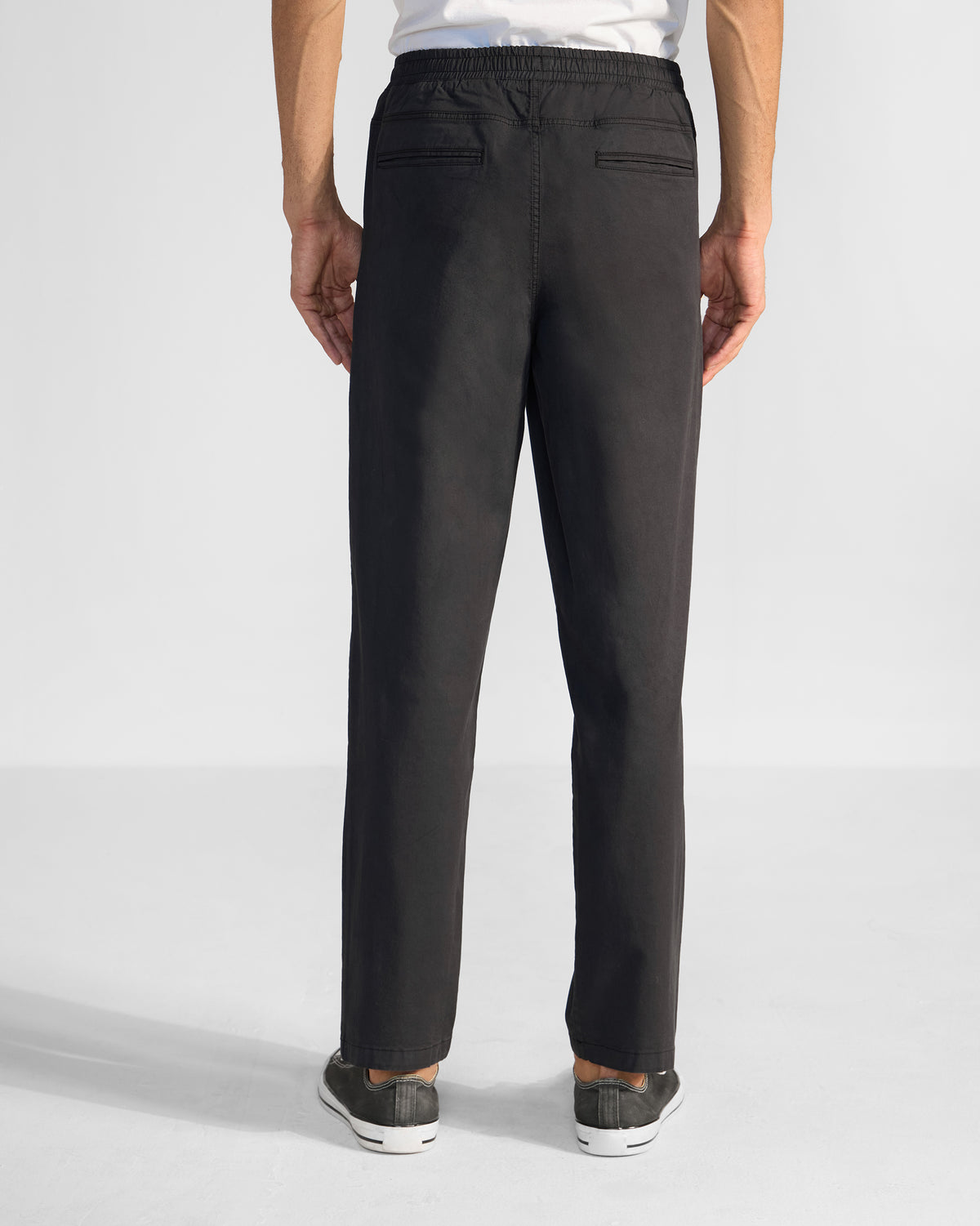 Back of black Pravah trousers showing the elastic waist and rear pockets.