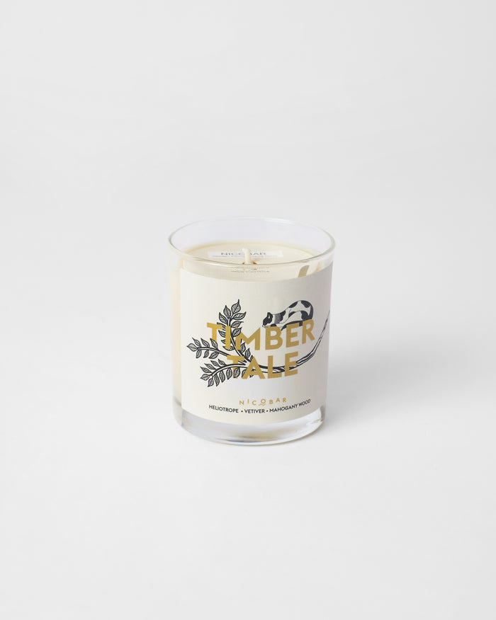 Timbertale Candle in a clear glass with a cream label and botanical sprig.