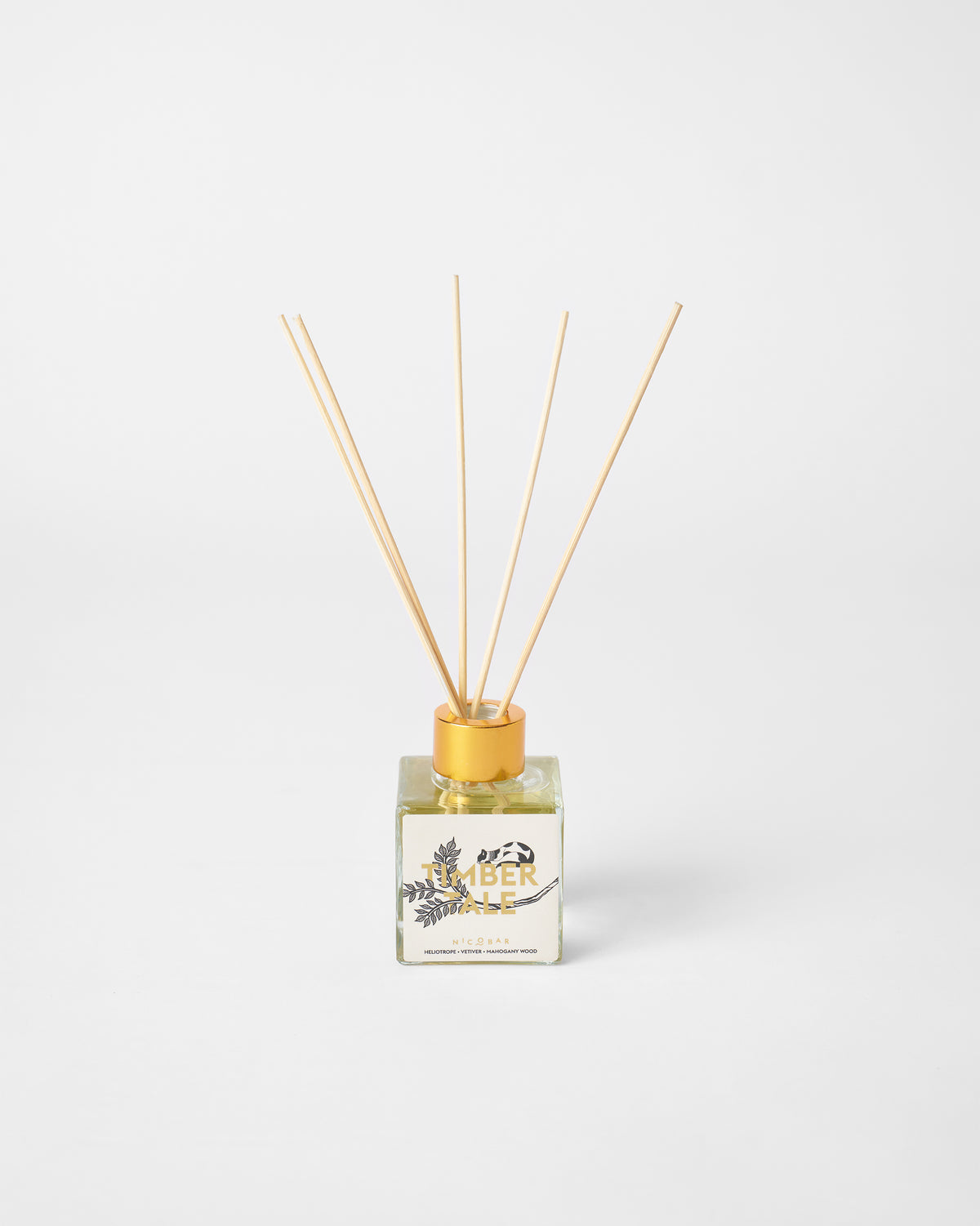 Timbertale Reed Diffuser with its reeds standing in a gold-capped glass.