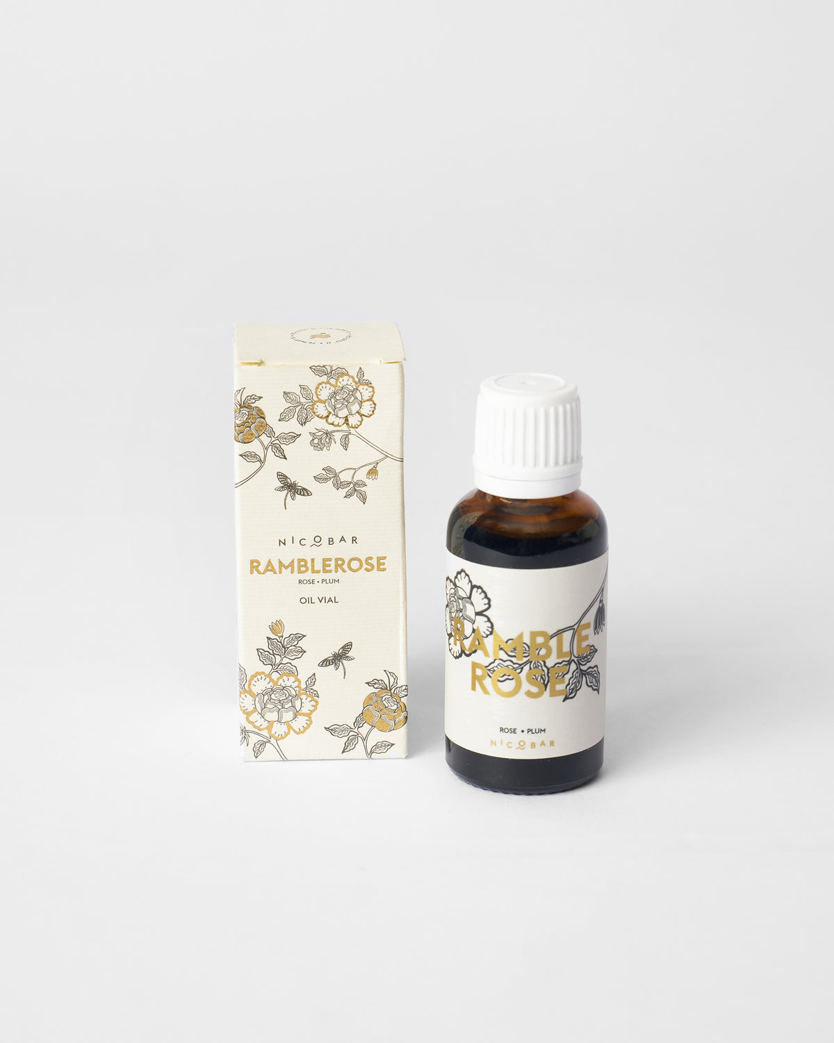 Ramblerose oil vial standing beside its cream rose-printed box.
