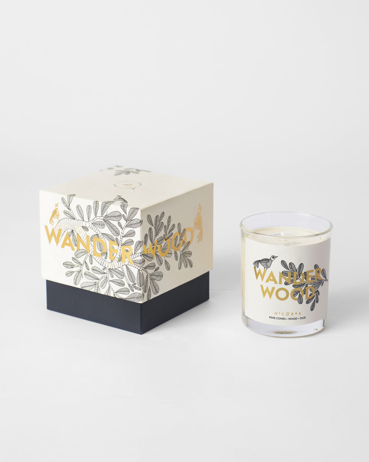 Wanderwood candle beside its white and navy illustrated gift box.