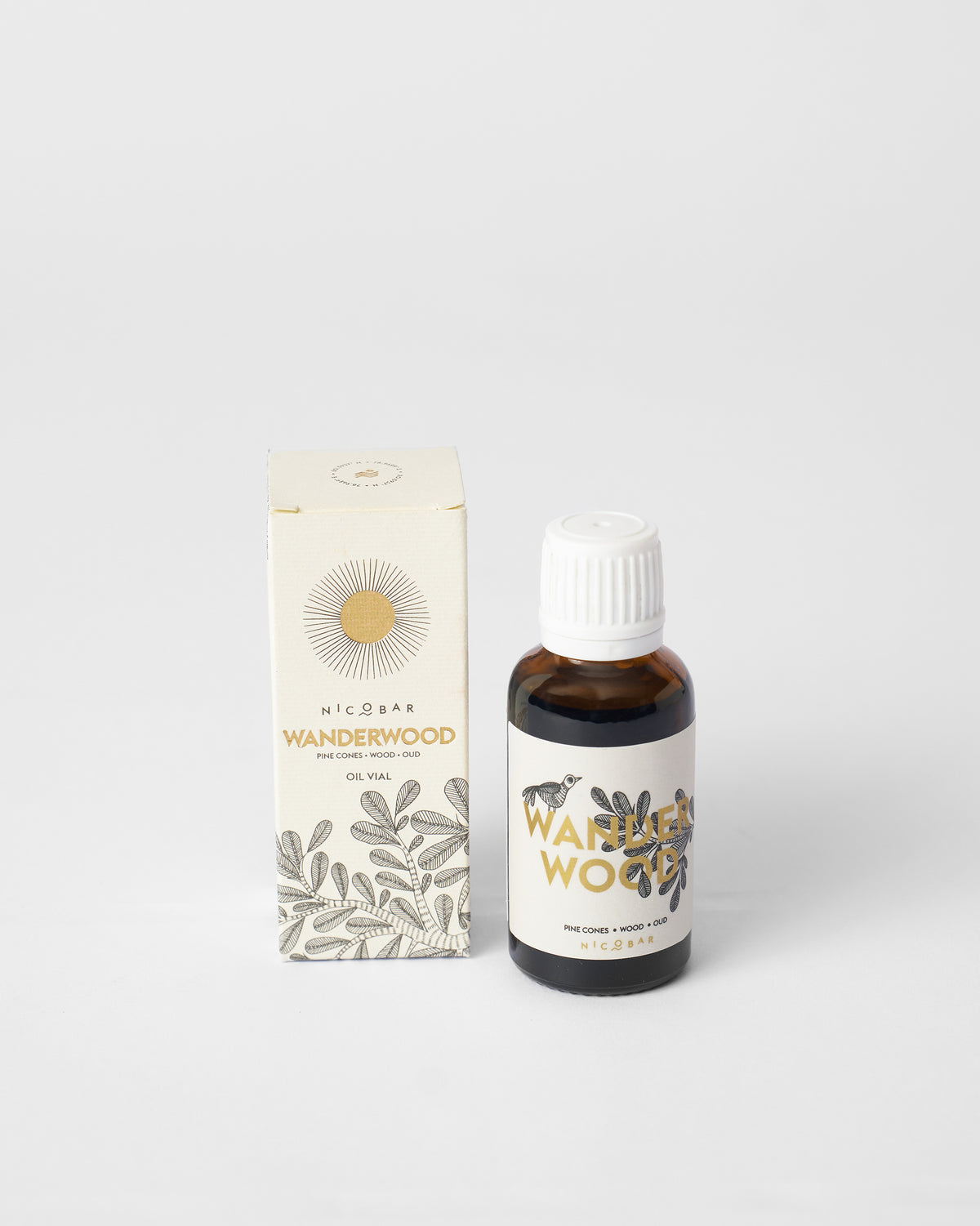 Wanderwood oil vial standing beside its cream illustrated gift box.
