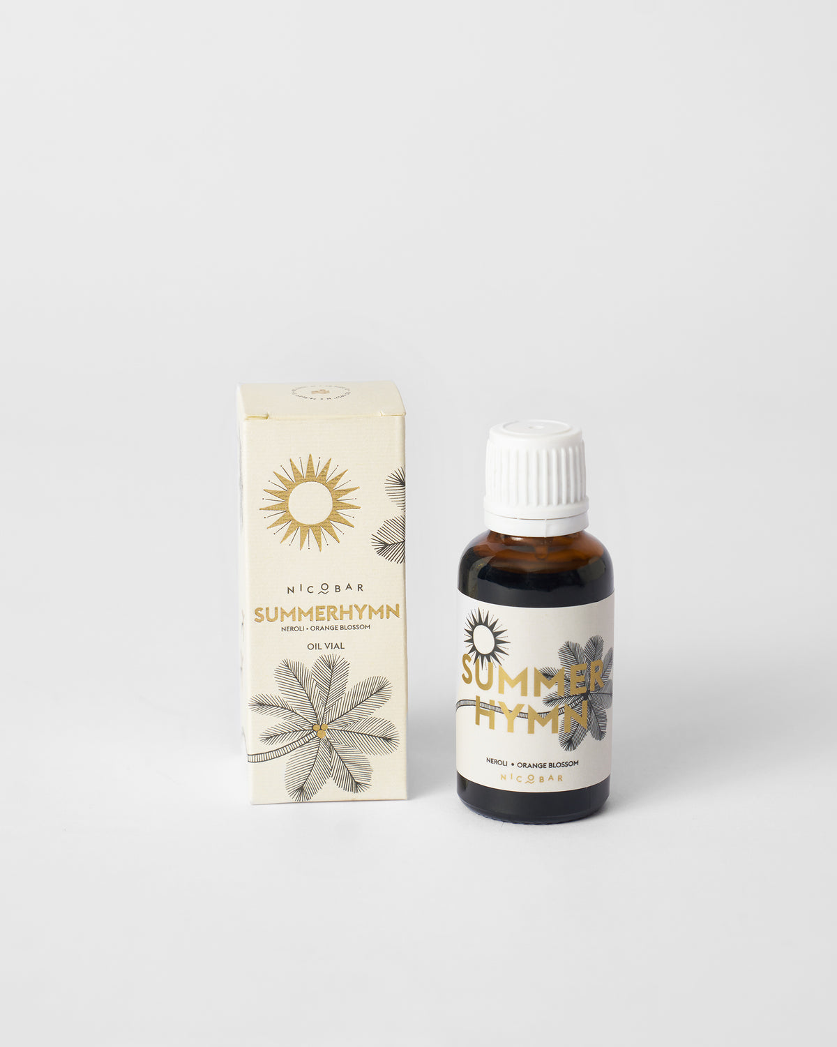 Summerhymn amber oil vial beside its cream Nicobar gift box.