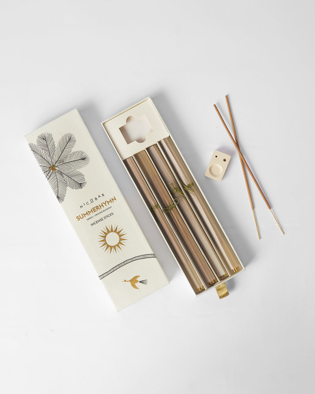 Open box of Summerhymn Incense Sticks with a ceramic holder and loose sticks beside it.
