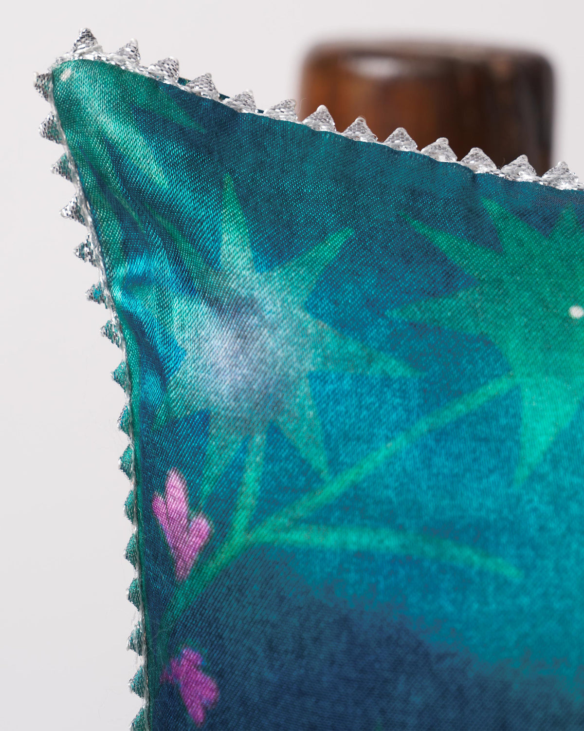 Corner of a Tusk Cushion Cover with beaded edging and star motifs.