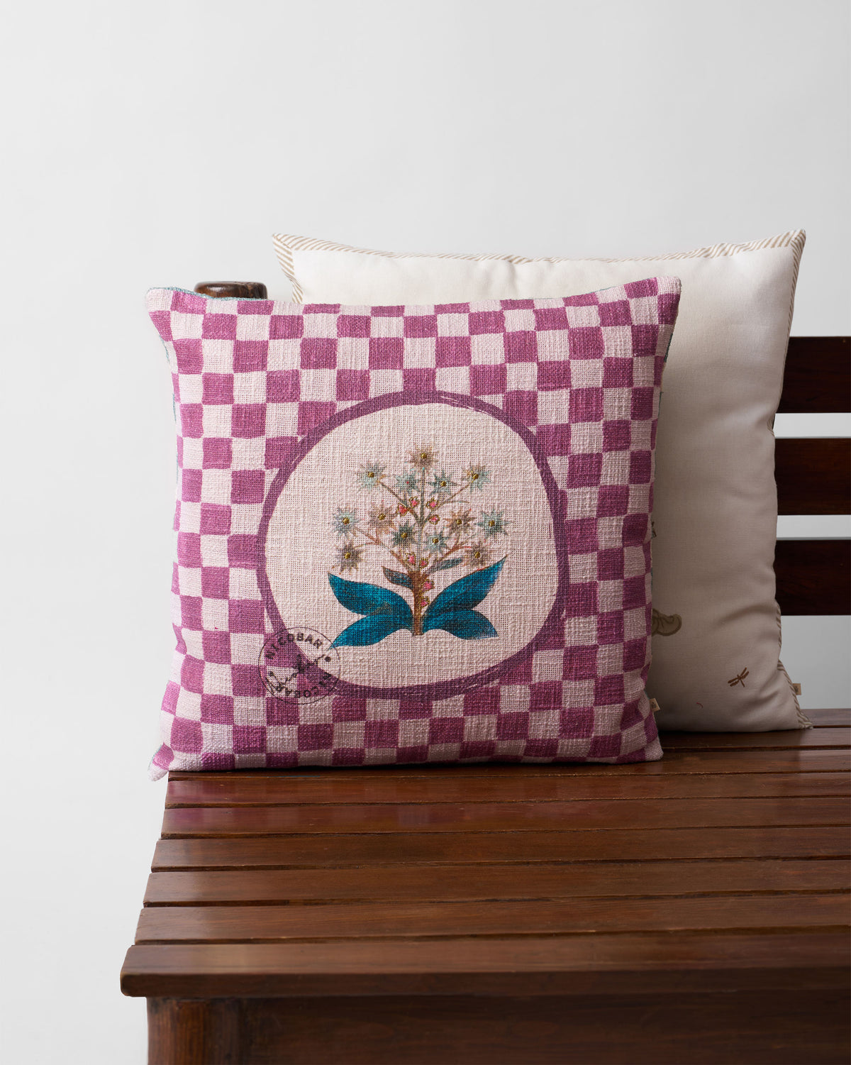 Mogra Bloom Cushion Cover with a flower in a circle on a mauve checkerboard.