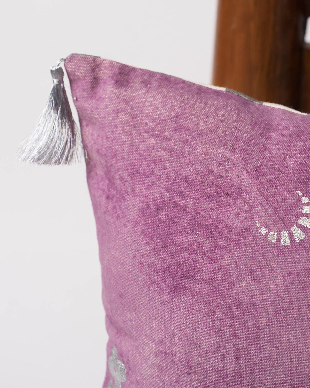 Close-up of Blooming Fern cushion cover corner with a silver tassel.