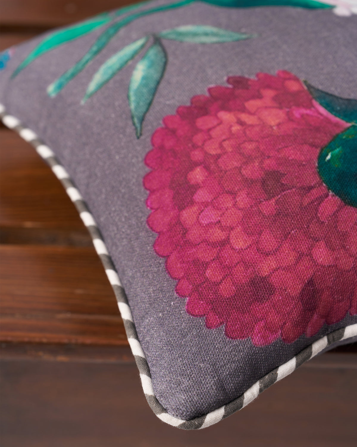 Close-up of magenta peony print and striped piping on the Peony car cushion.